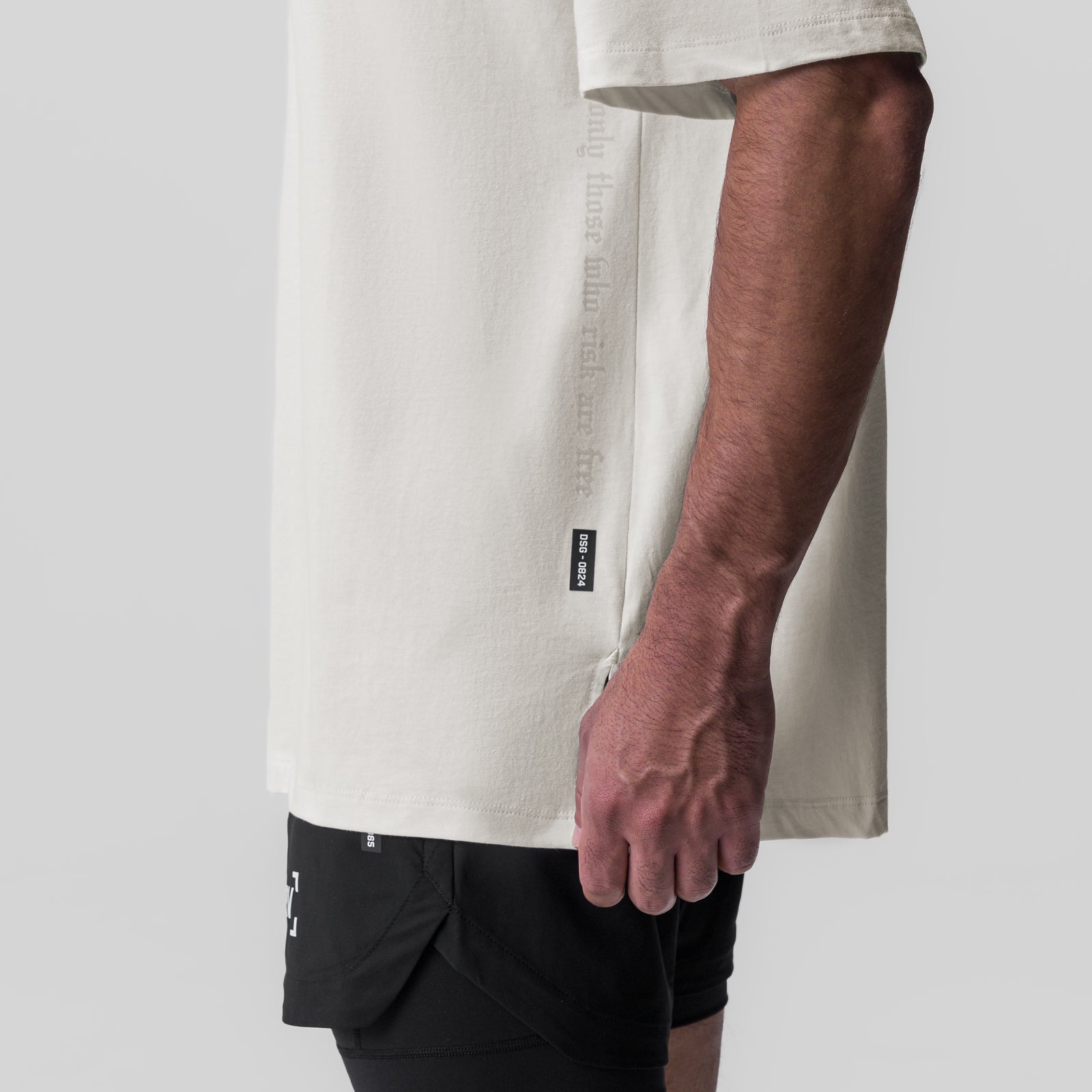 Ivory cream oversized tee worn by model with black shorts, side view