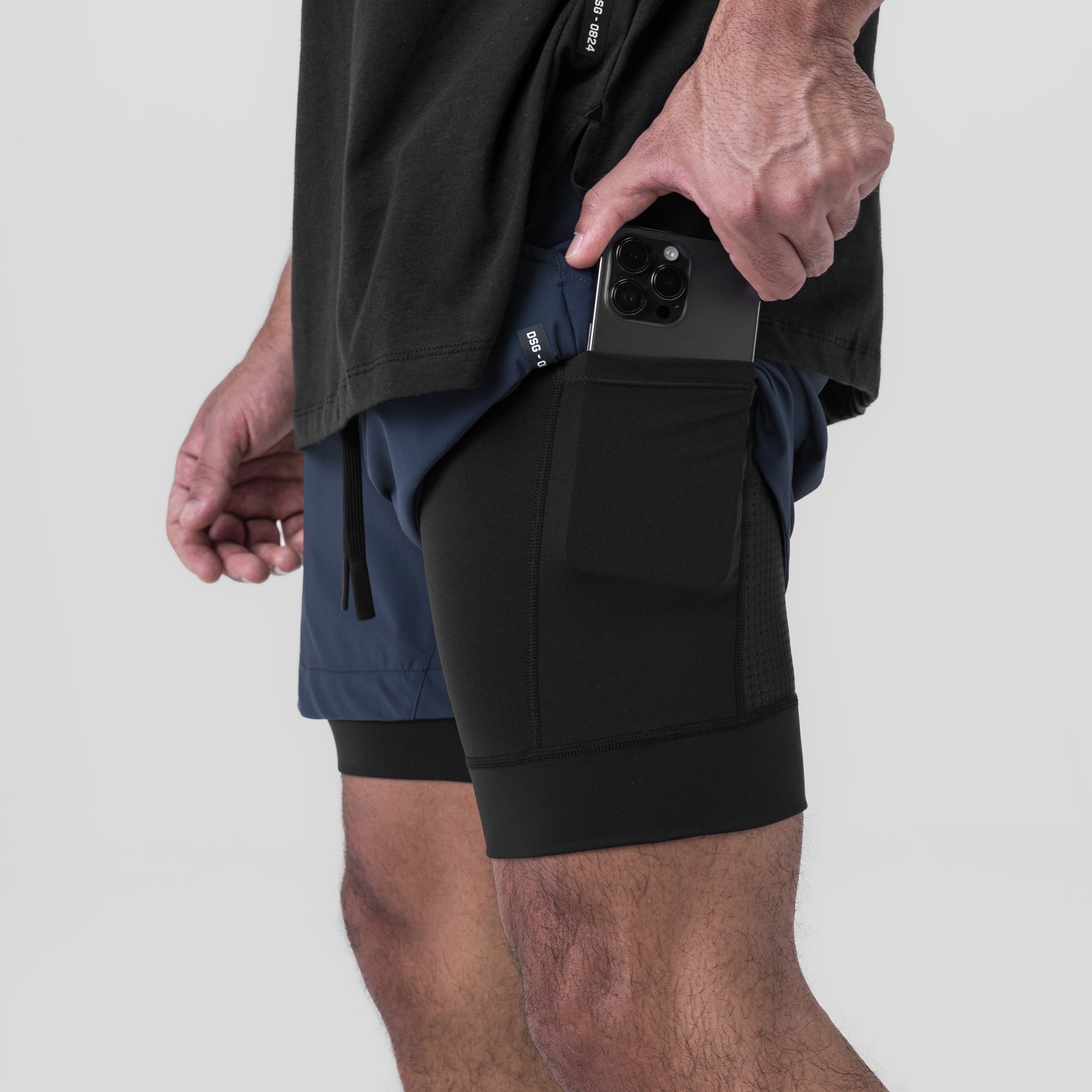 Tetra-Lite 5" Liner Short in Navy and Black, worn by model holding phone in pocket