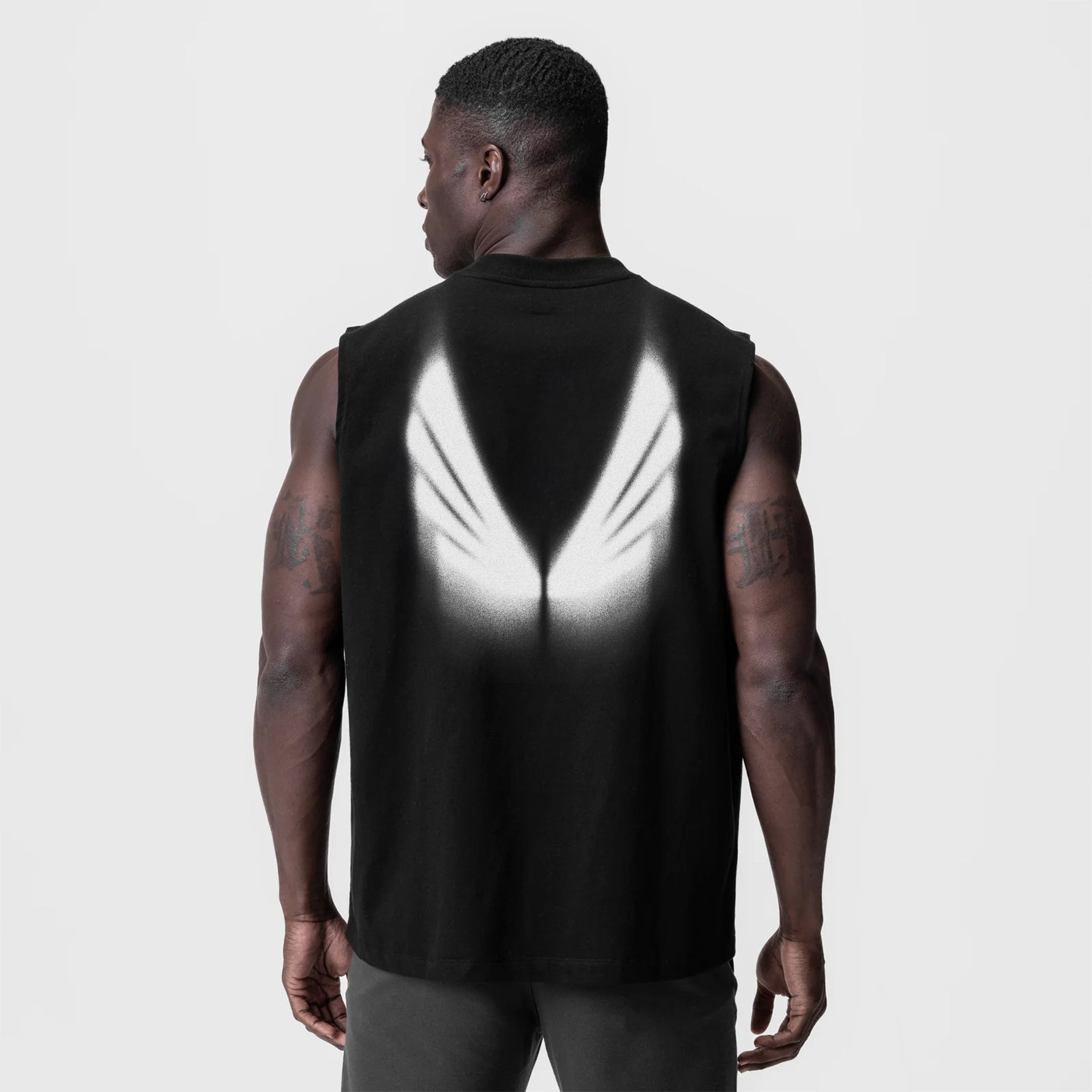 Tech Essential Relaxed Cutoff in black worn by model, back view showing reflective graphic