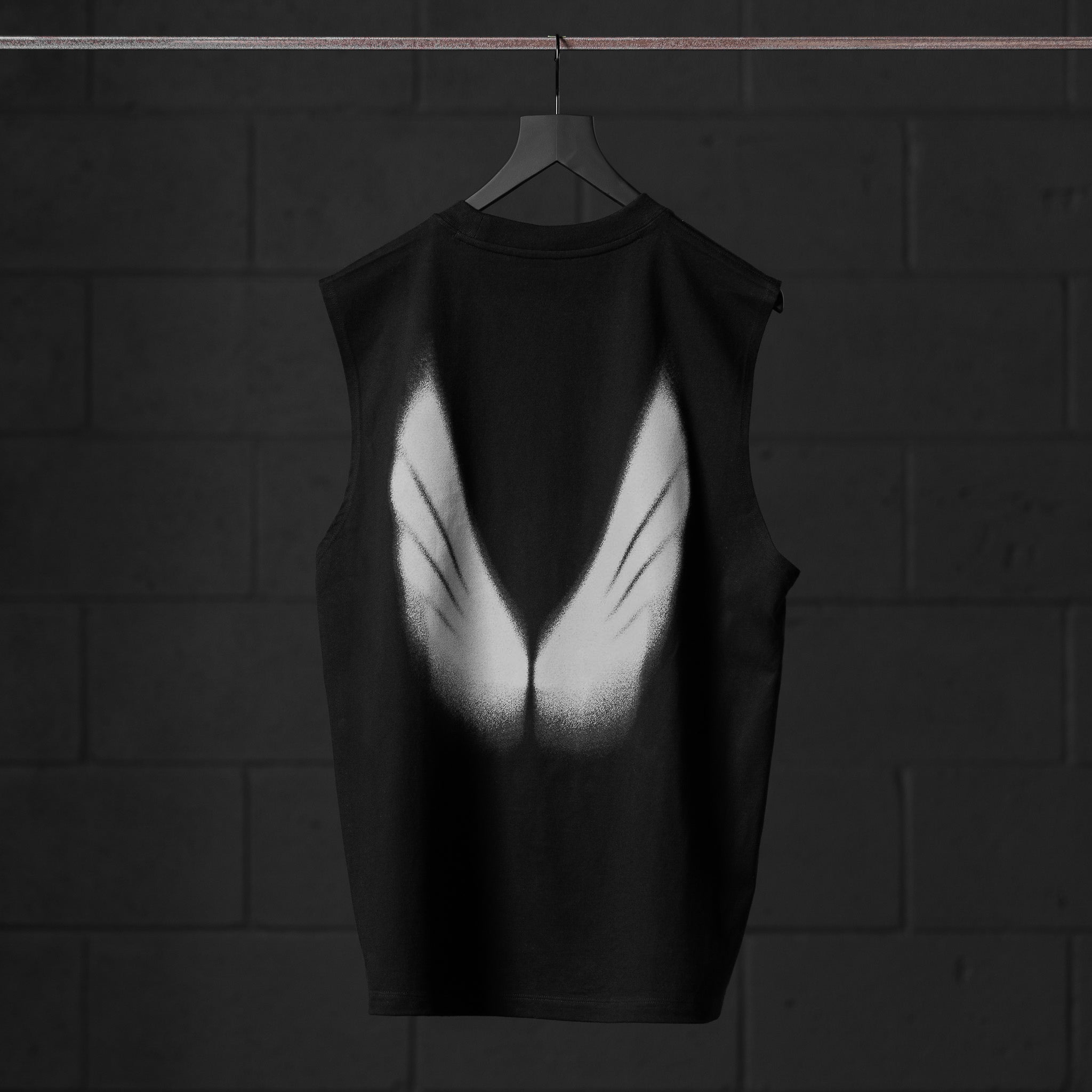 Tech Essential Relaxed Cutoff tank top in black with white graphic print, back view on hanger