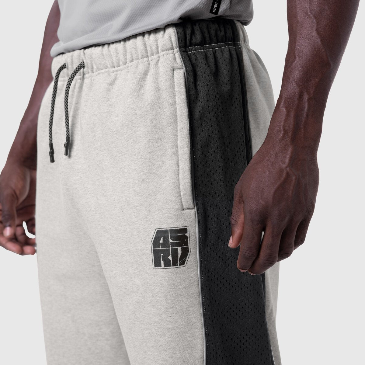 Tech-Terry Mesh Panel Sweats in heather grey with black mesh panels, worn by model, side view