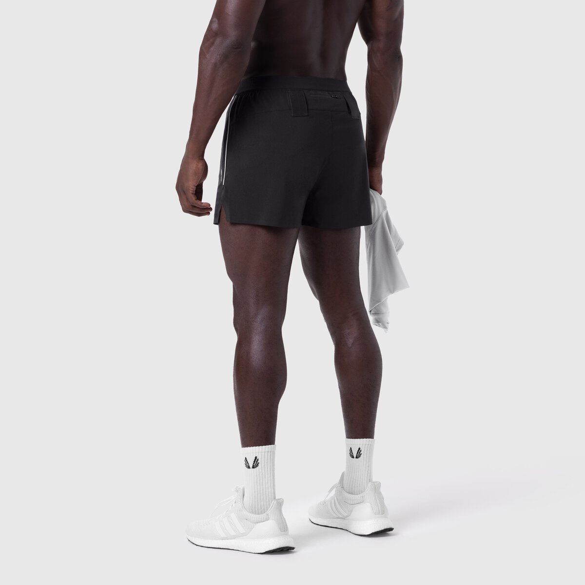 Aerotex 3" Distance Short in black, worn by model from behind, paired with white socks and sneakers