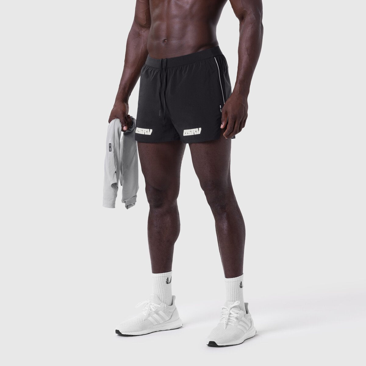 Aerotex 3" Distance Short in black, worn by model holding gray jacket