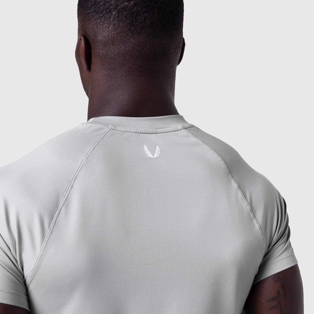 AeroSilver Established Tee in slate grey worn by model, back view showing logo