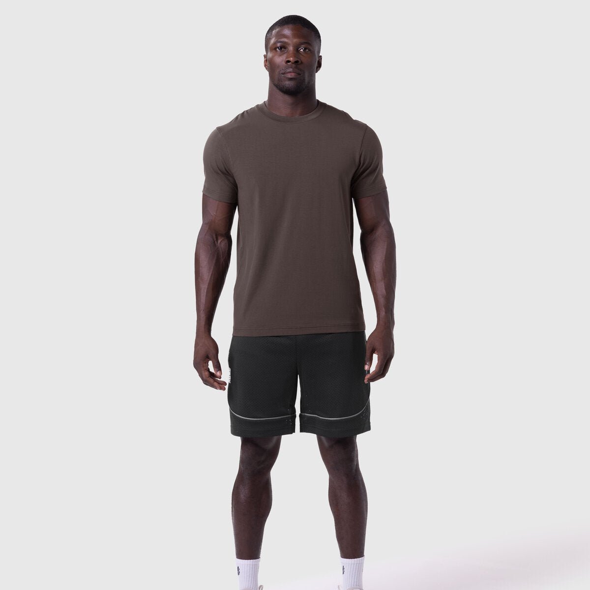 Supima Essential Tee in Dark Earth worn with black shorts, front view on model