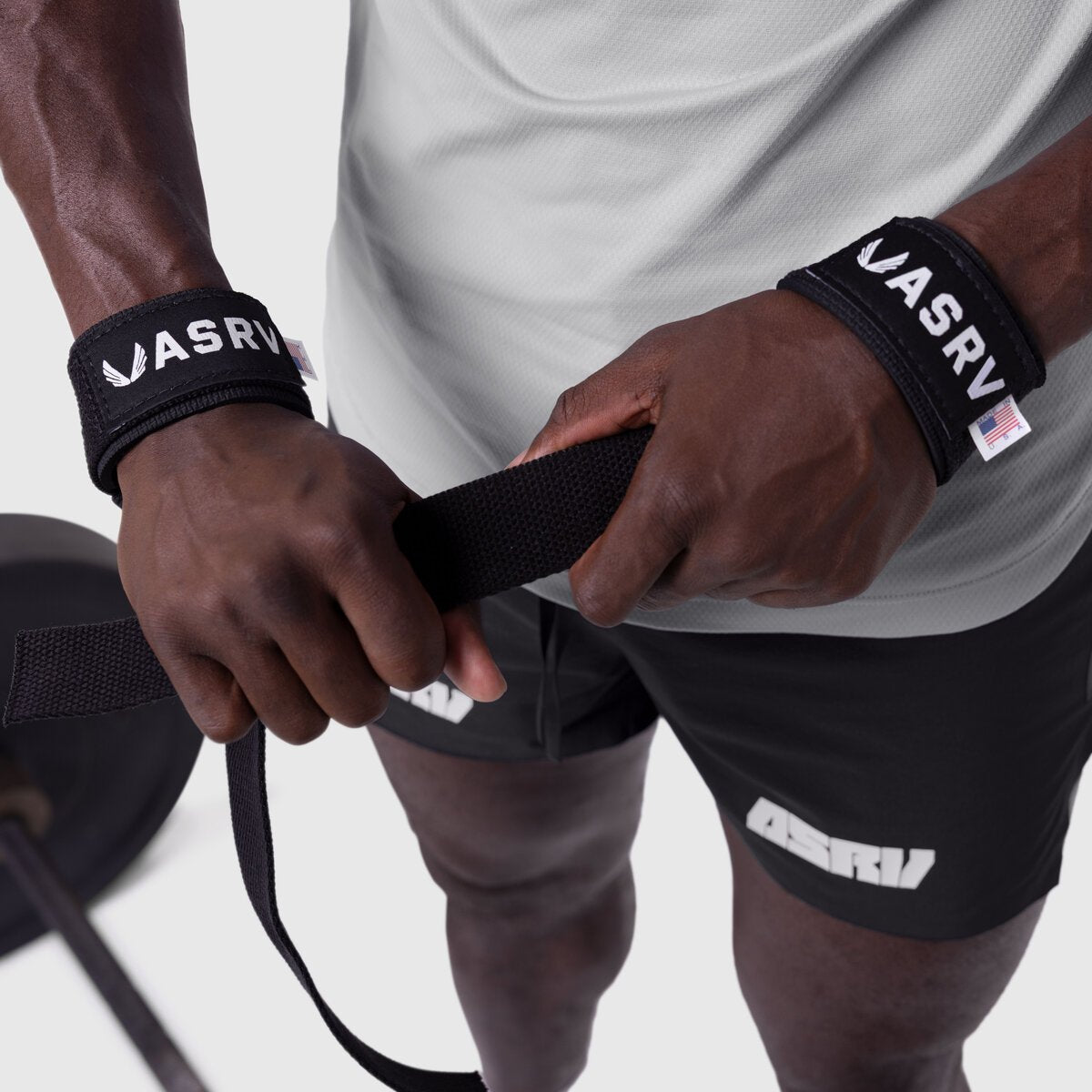 Padded Lifting Straps in black worn on wrists, held around exercise equipment