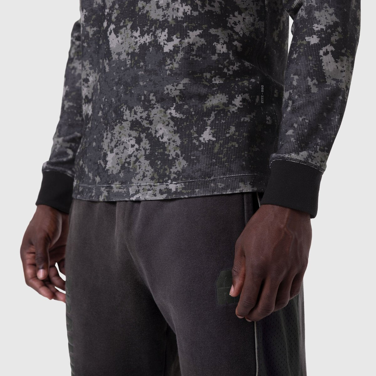 Waffle Knit Longsleeve in pixel camo worn with dark pants, detail shot
