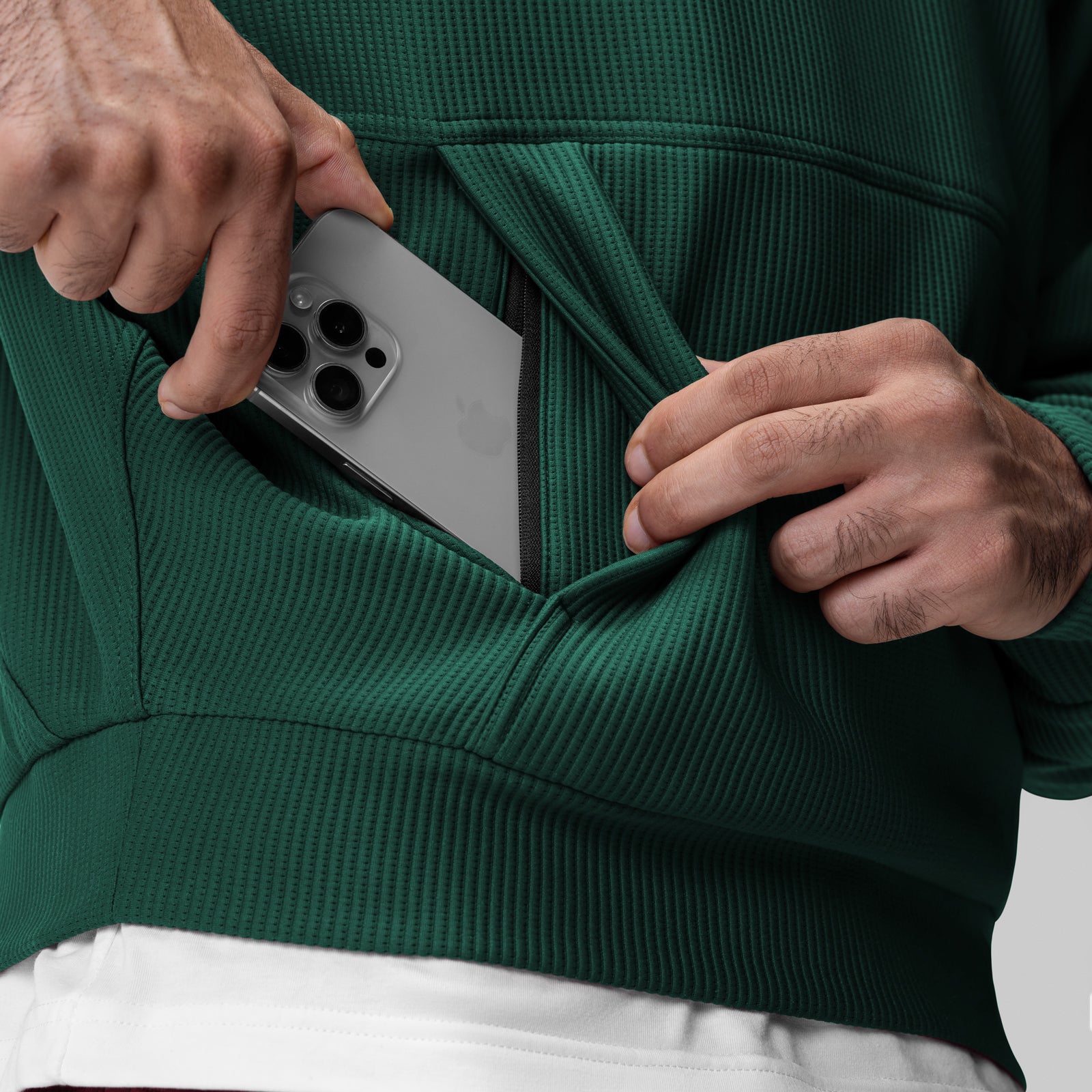 Deltapeak® Oversized Hoodie in forest green, worn by model holding smartphone in pocket