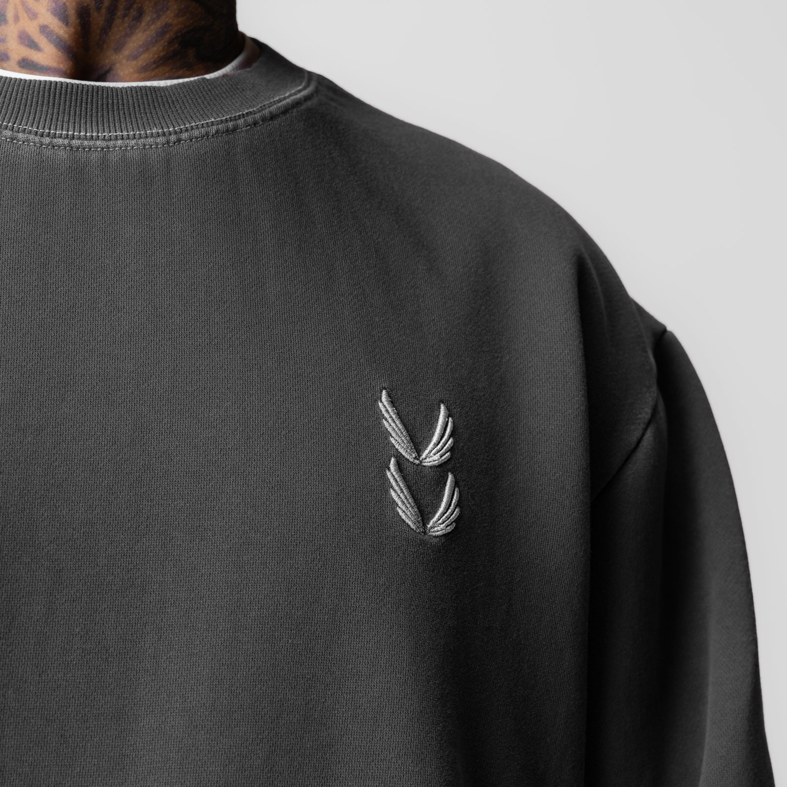 Tech Essential Distressed Crewneck in faded grey worn by model, chest detail view