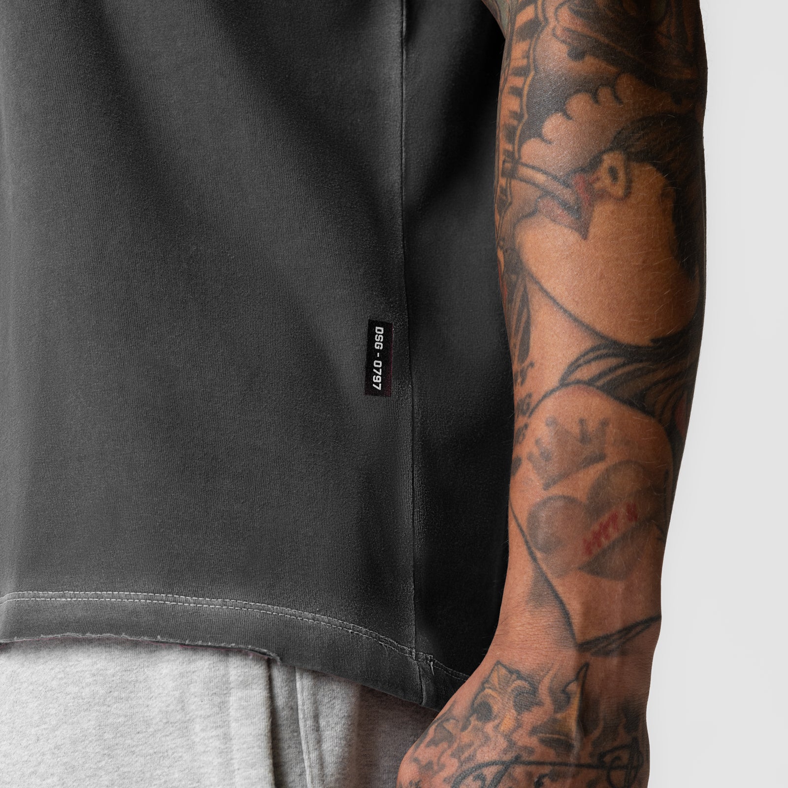 Tech Essential Relaxed Tee in faded grey worn by model with visible tattoos on arm