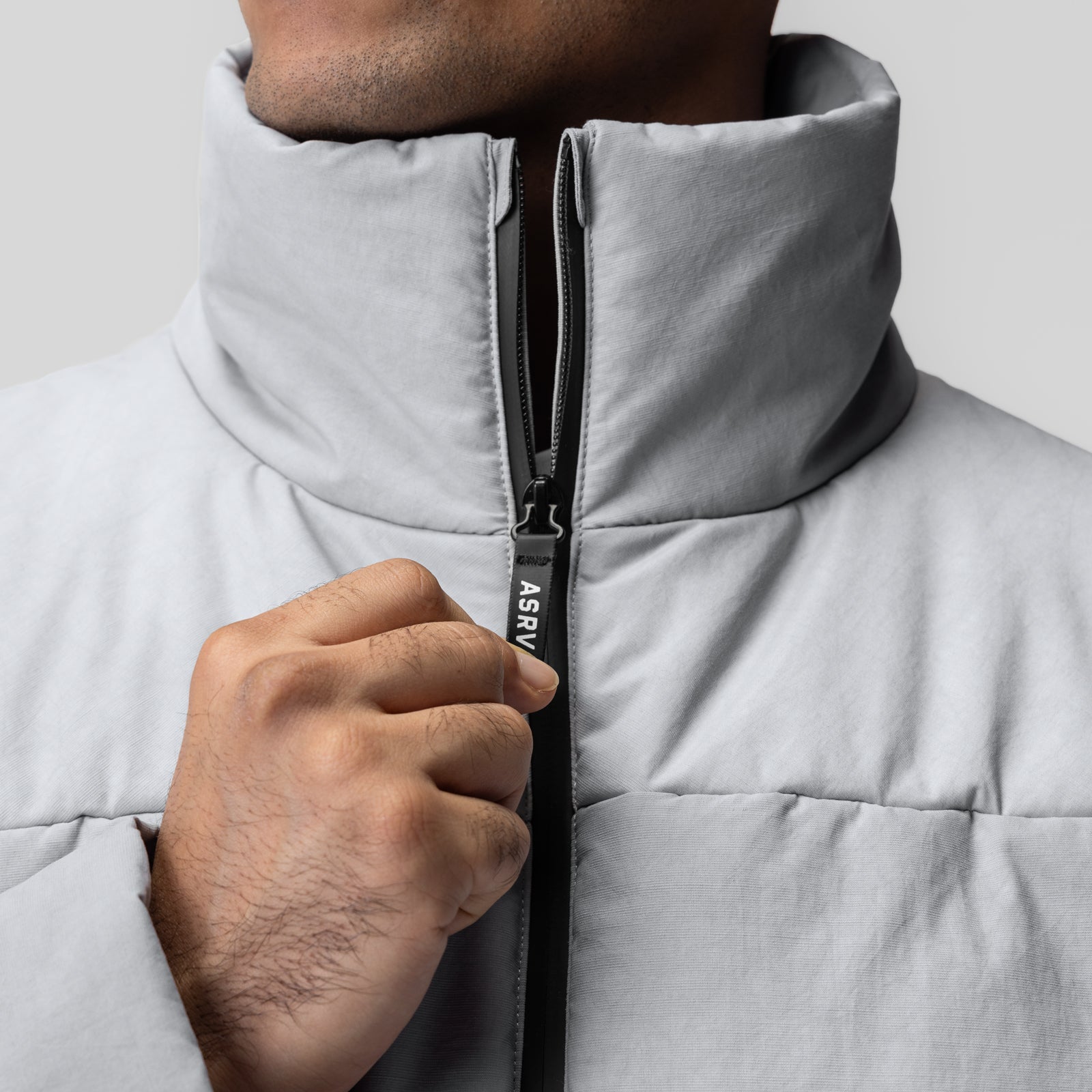 PrimaLoft Weather-Ready Puffer Jacket in grey, model wearing jacket with hand on zipper