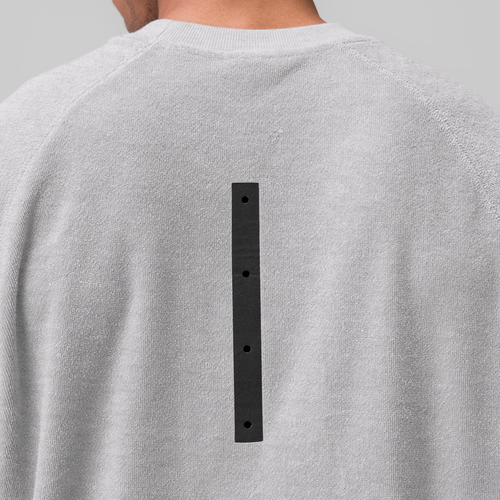 Towel Terry Cutoff in heather grey worn by model, back view showing black button detail