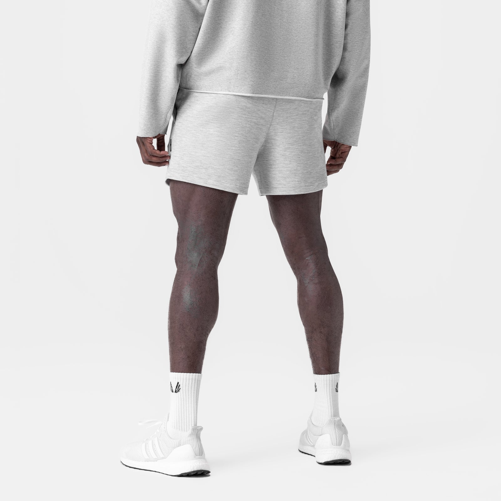 Heather grey waffle knit sweat shorts worn with matching hoodie, back view on model