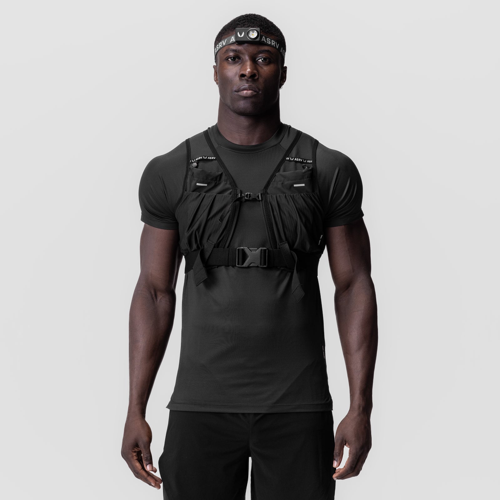 Black tactical vest worn over charcoal t-shirt with headband, front view