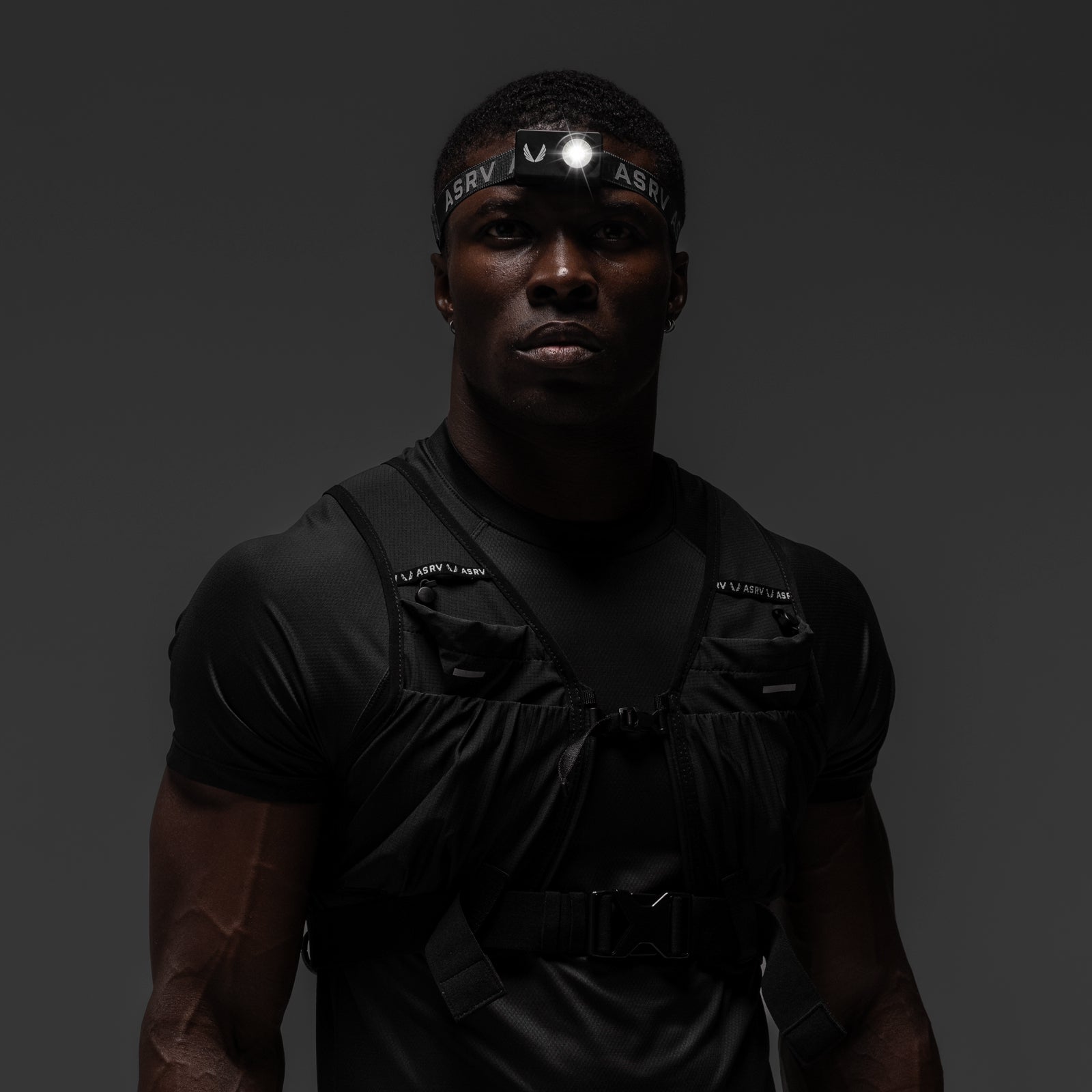 Black ASRV x Bookman Monocle tactical vest worn by male model with headlamp