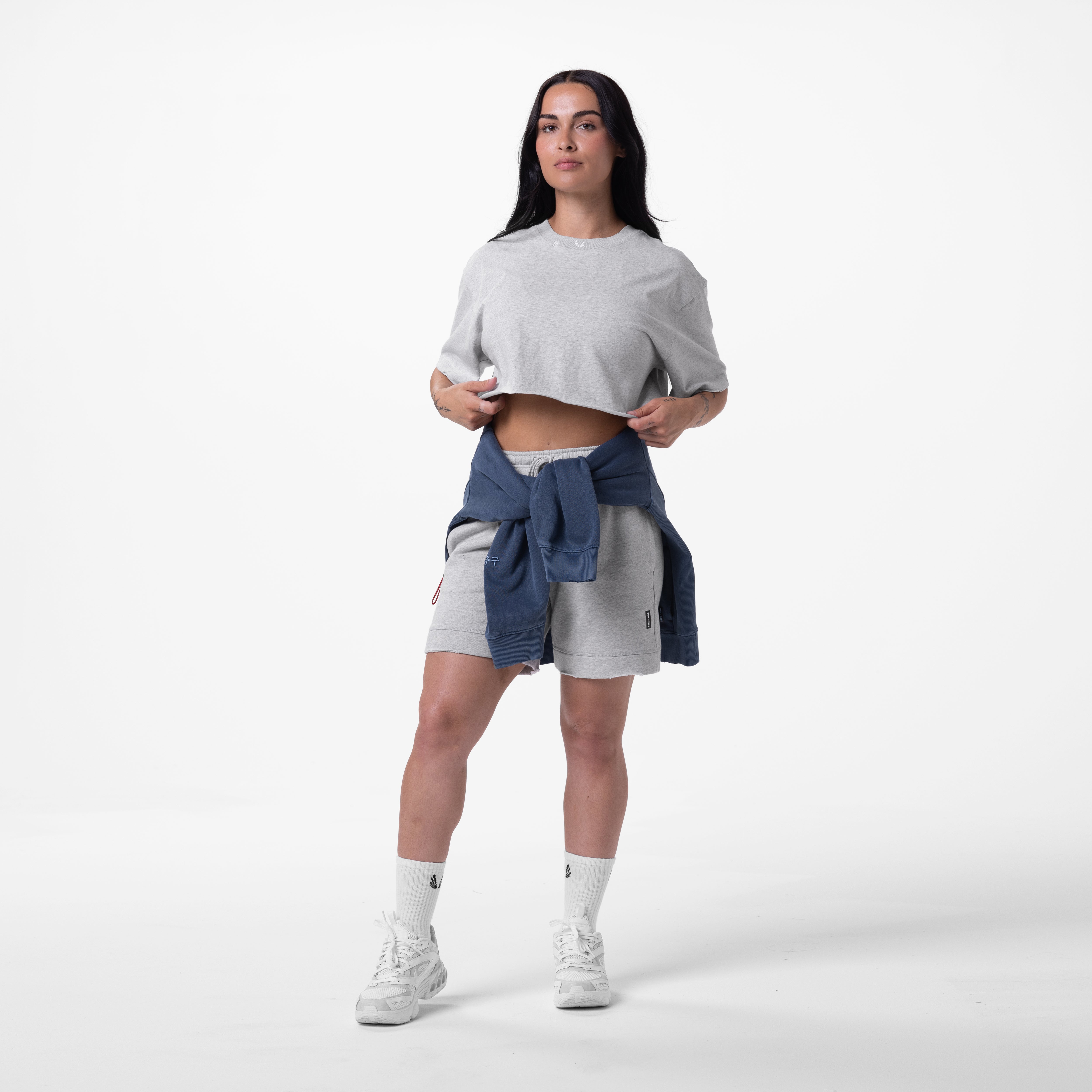 Tech Essential Sweat Short in Heather Grey, model wearing cropped tee and shorts with navy jacket tied at waist