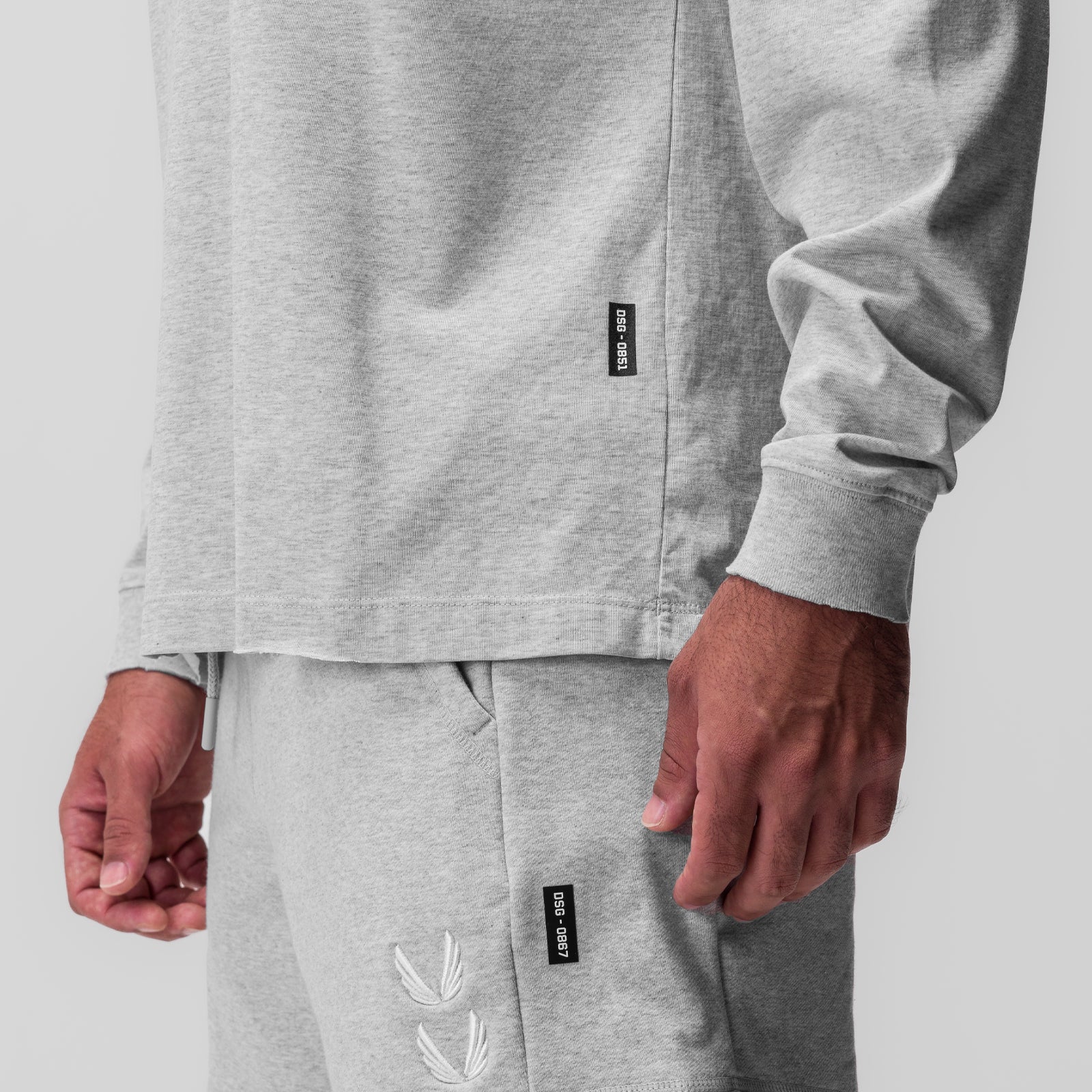 Tech Essential Relaxed Long Sleeve in heather grey worn by model, detail view of torso and hands