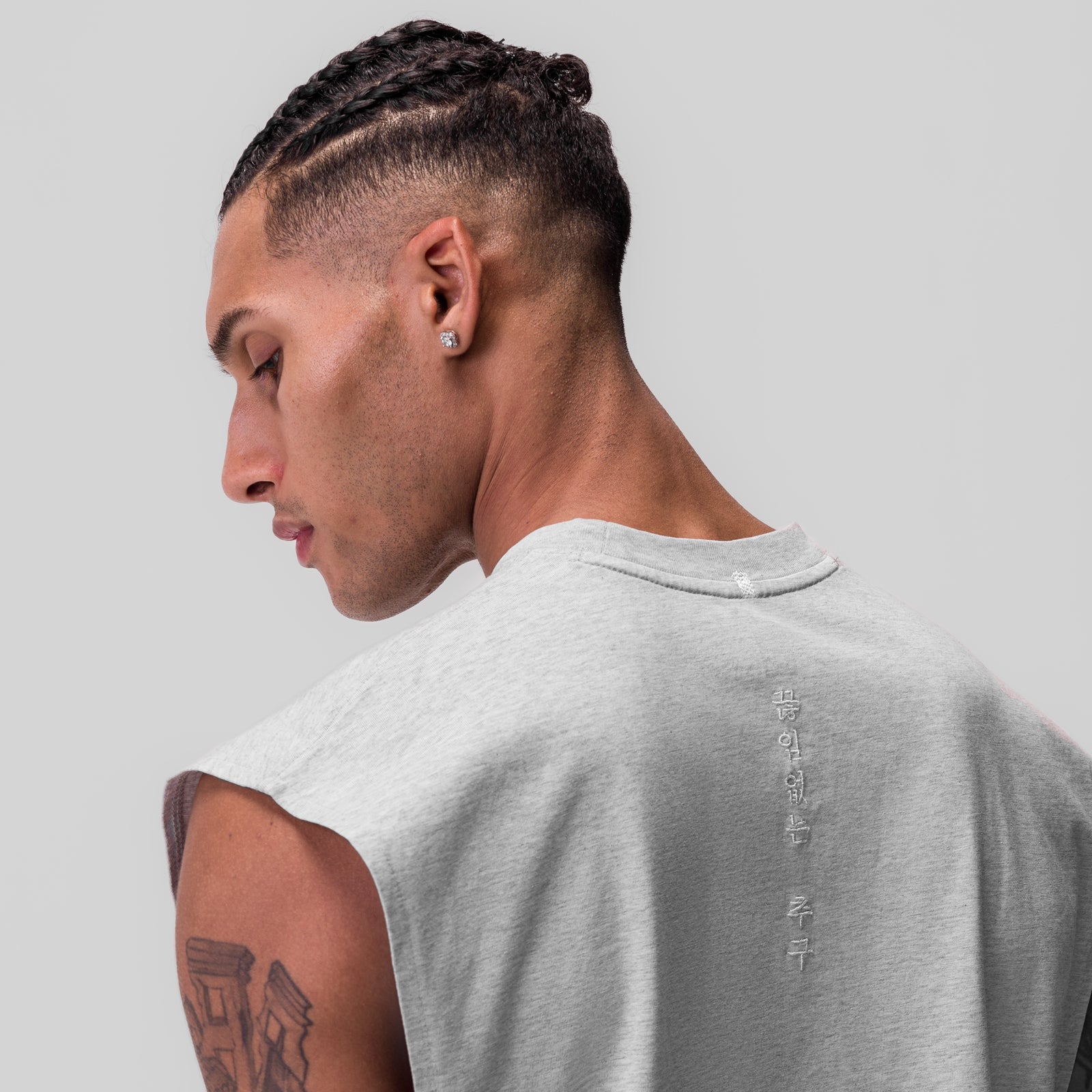 Tech Essential Rocker Cutoff sleeveless tee in heather grey, worn by model shown from side profile
