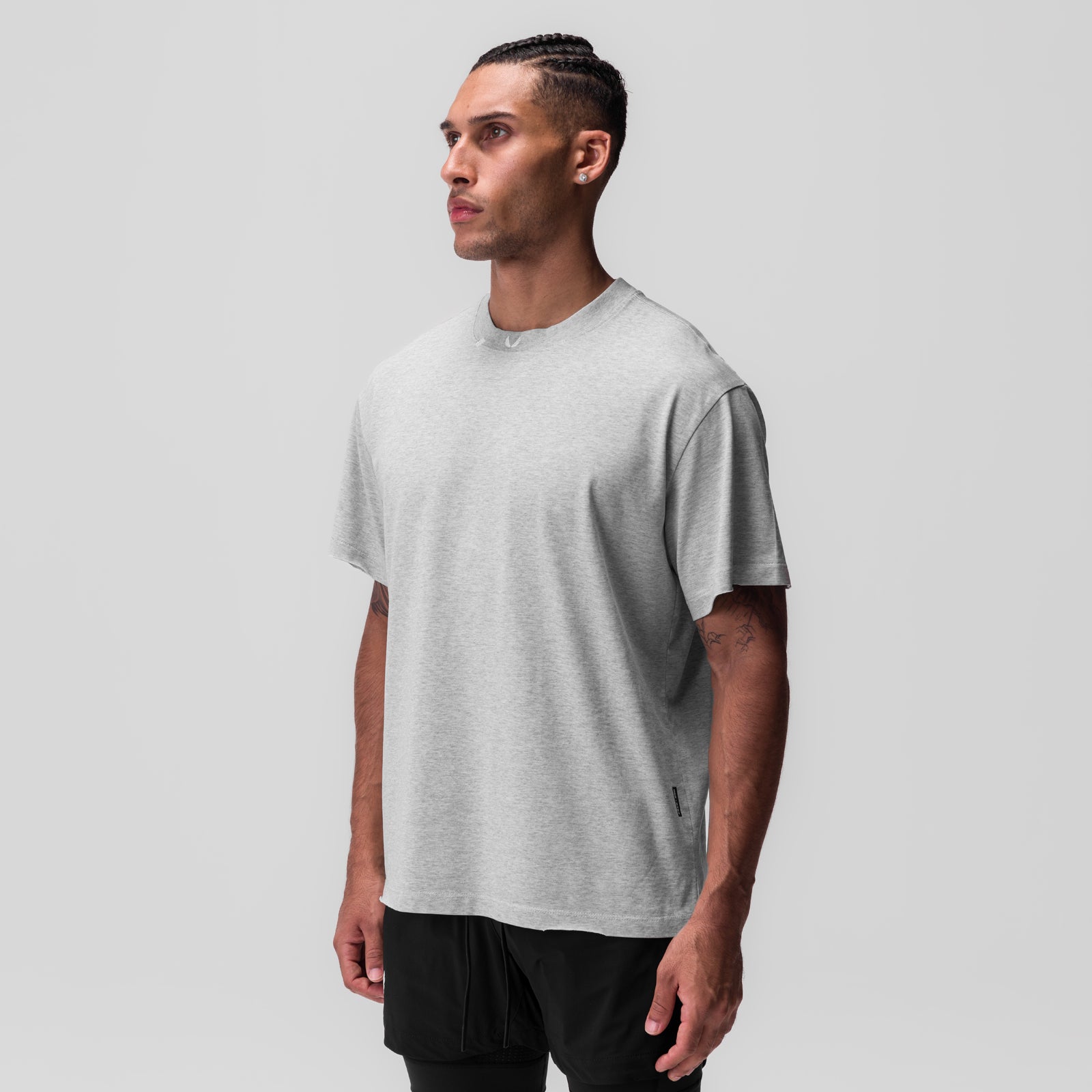 Tech Essential Relaxed Tee in heather grey, worn by model in profile view