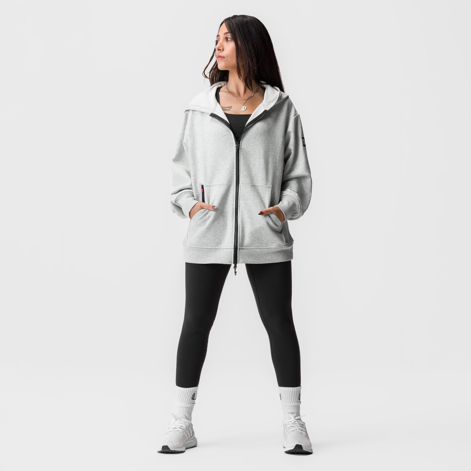 Heather grey oversized zip hoodie worn with black leggings and white socks, front view