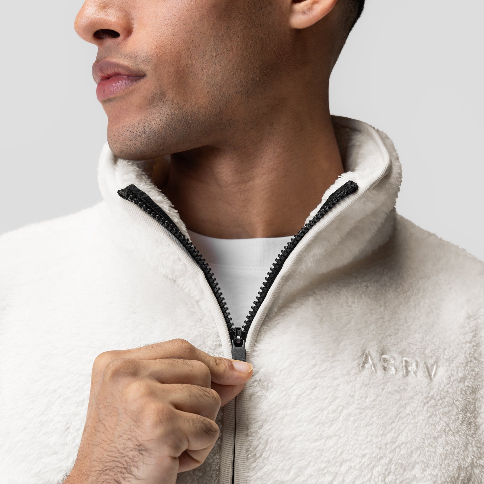 Sherpa Recovery 1/2 Zip in ivory cream with black zipper, worn by model in profile