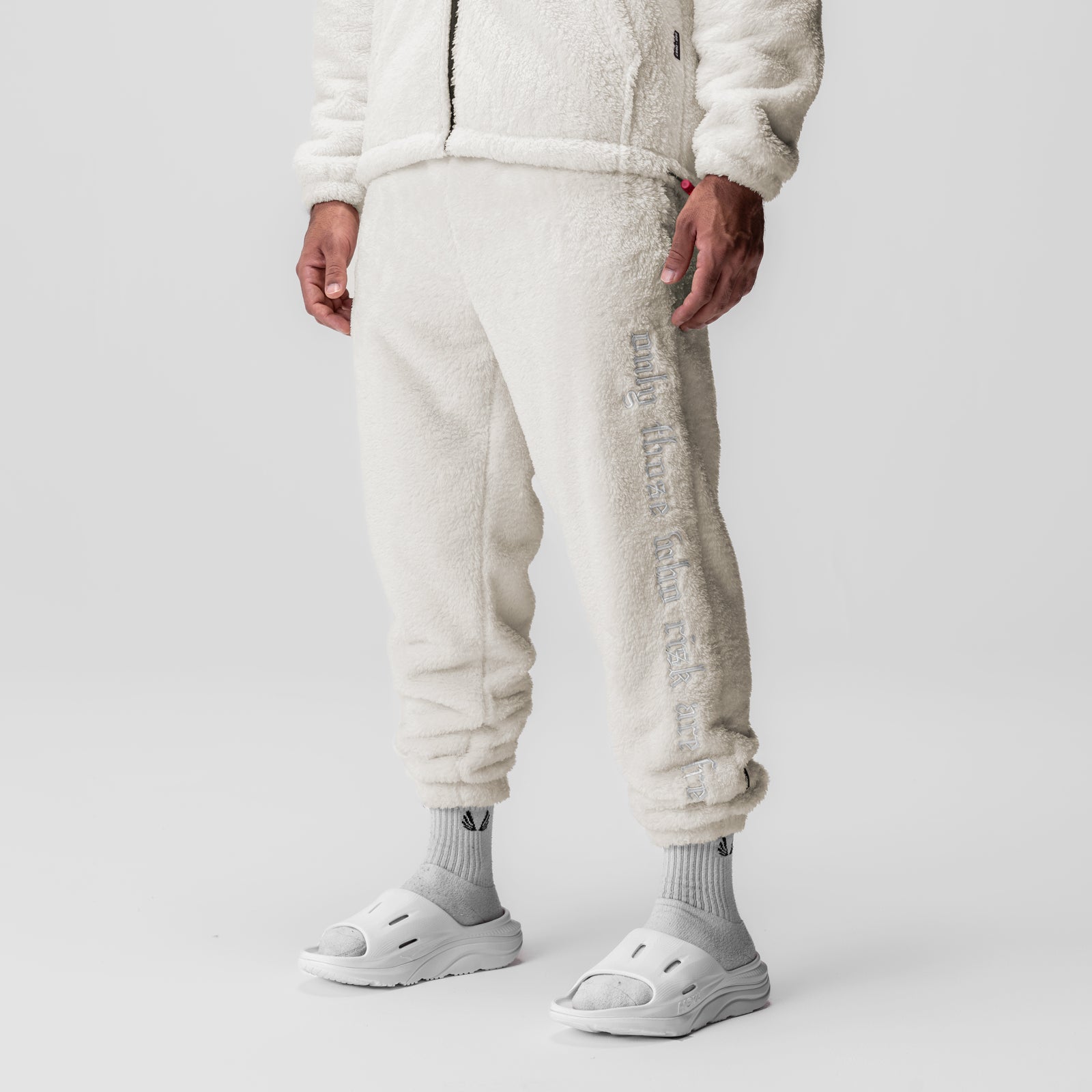 Sherpa Recovery Sweats in ivory cream worn by model, lower body view with white socks and sandals