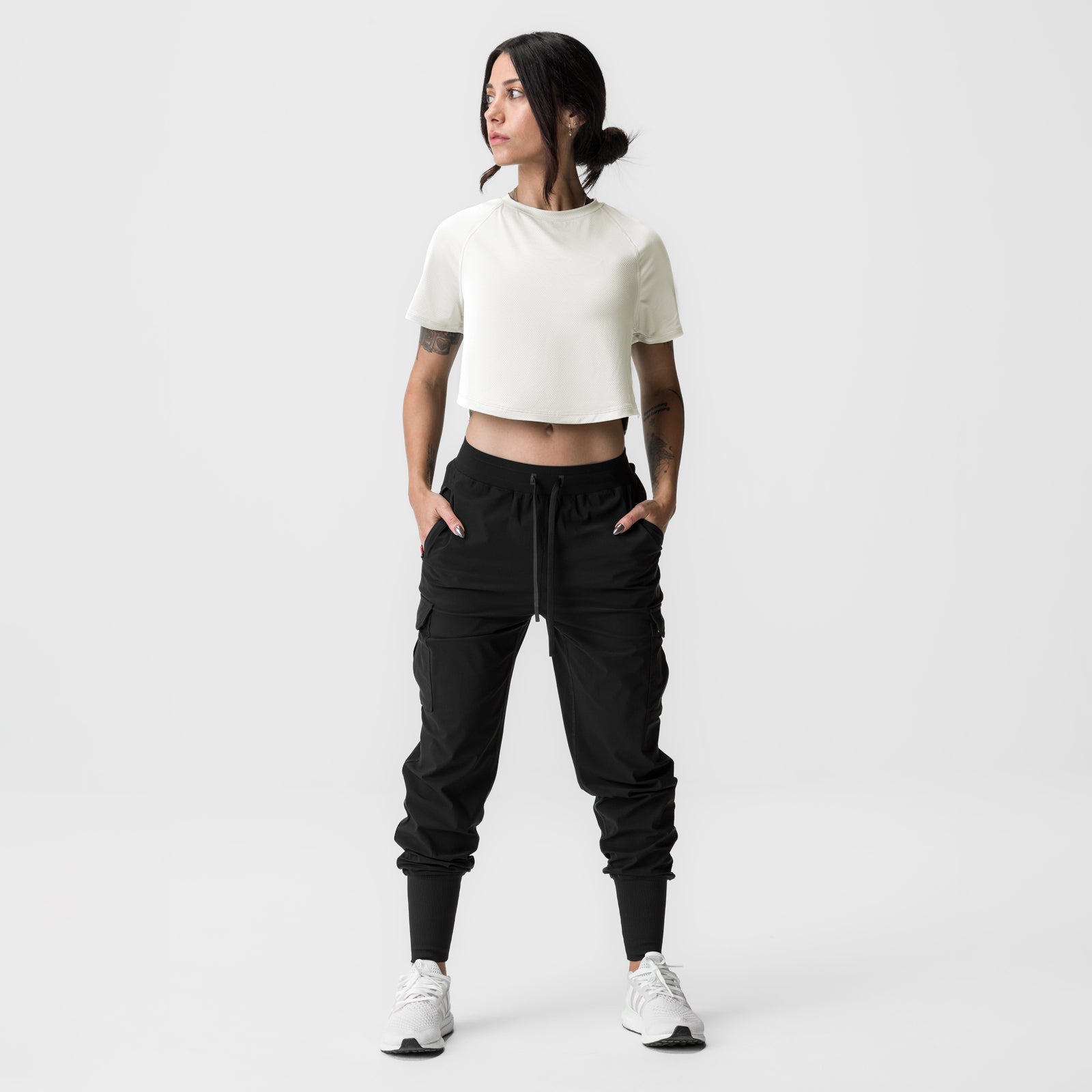 Ivory cream cropped training tee worn with black cargo joggers and white sneakers, front view