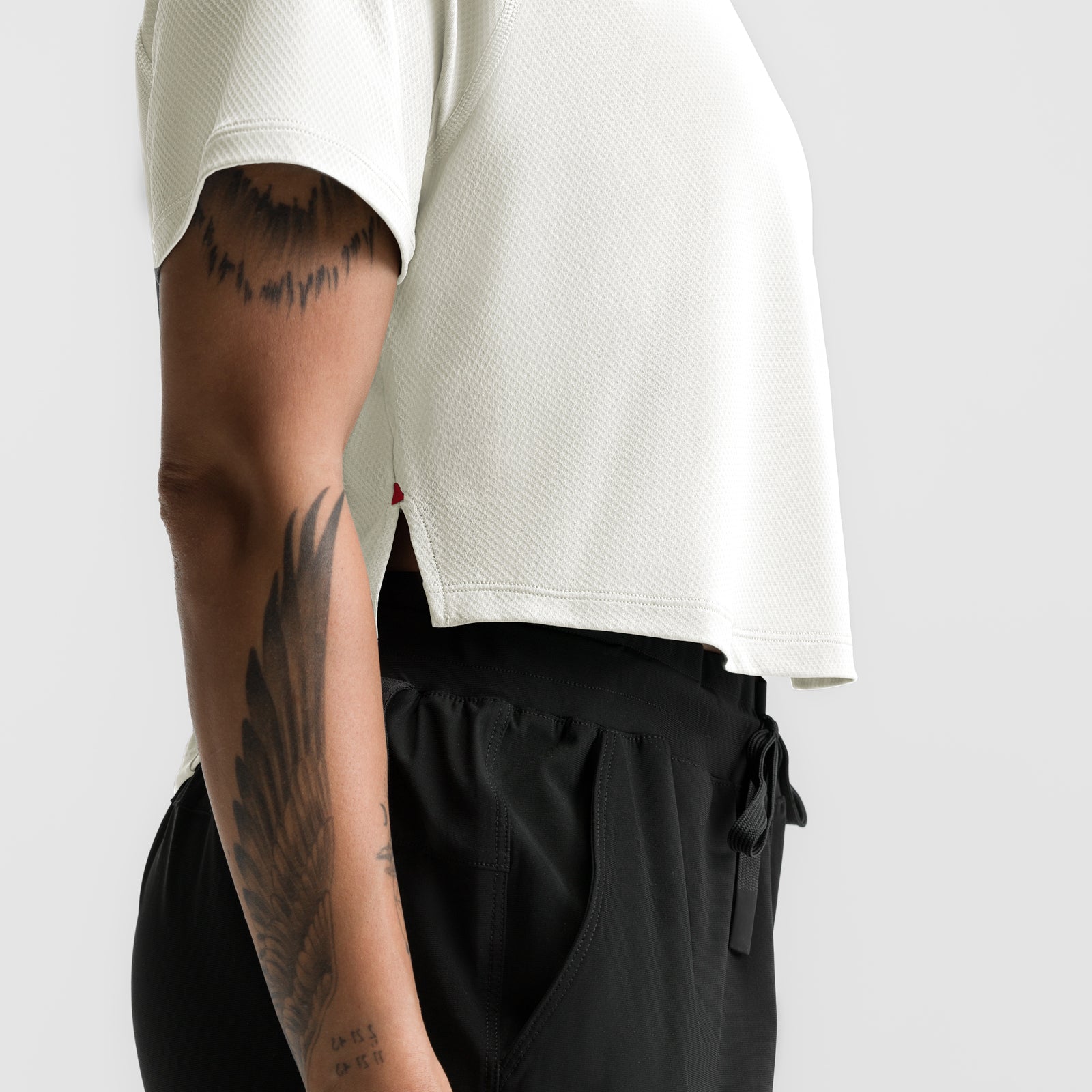 Ivory cream cropped training tee worn by model showing side view and fit