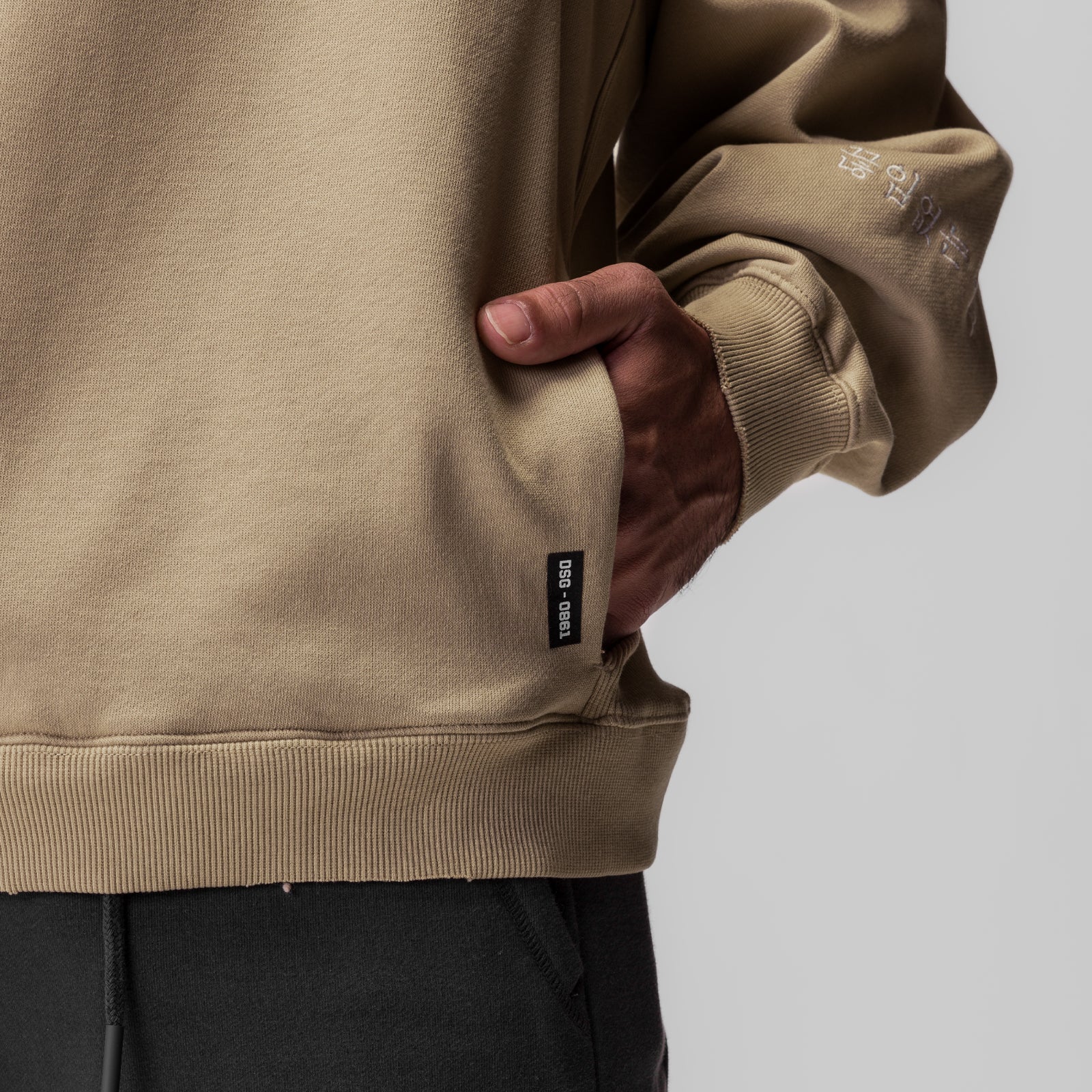 Tech Essential™ Distressed Crewneck in khaki, worn with hand in pocket detail shot