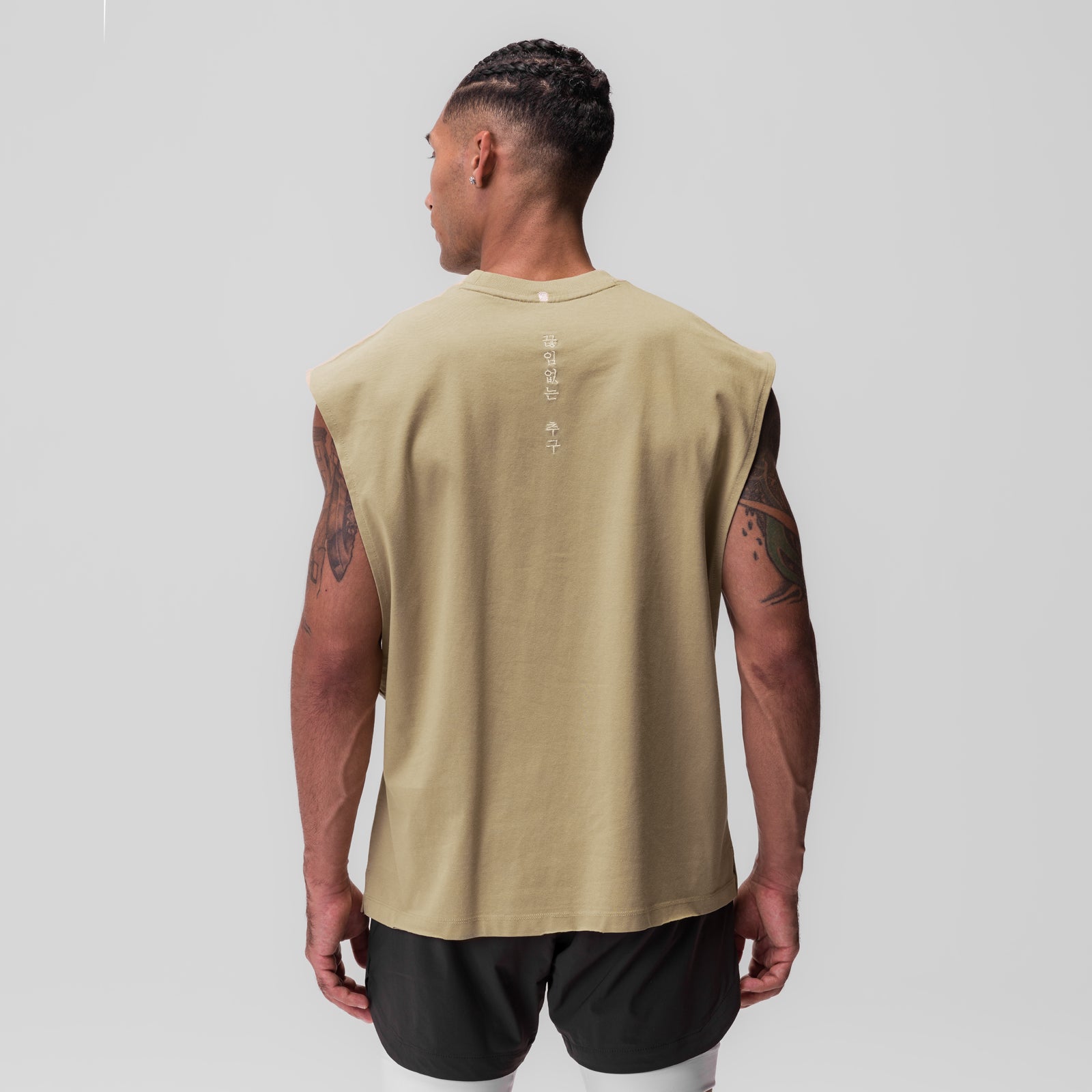 Tech Essential Rocker Cutoff tank top in khaki, back view on model