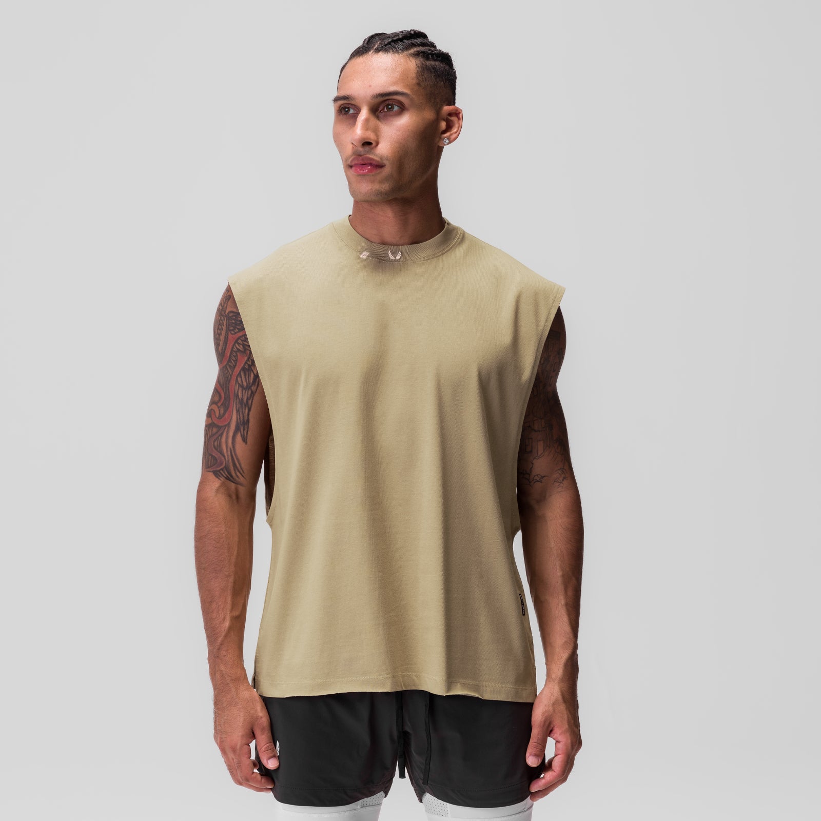 Tech Essential Rocker Cutoff sleeveless tank in khaki, worn by model with black shorts