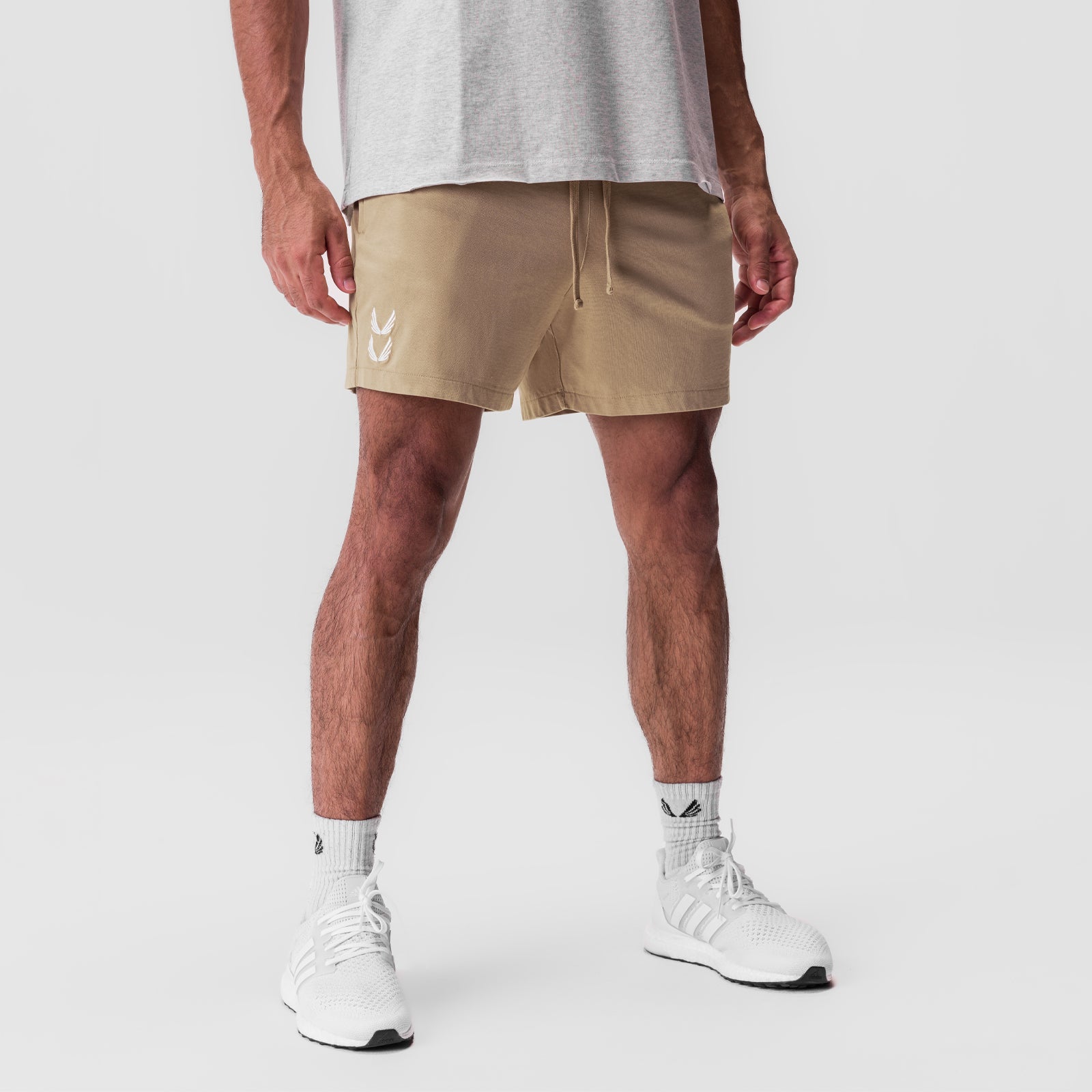 Tech Essential Sweat Shorts in khaki, worn by model with white sneakers and socks