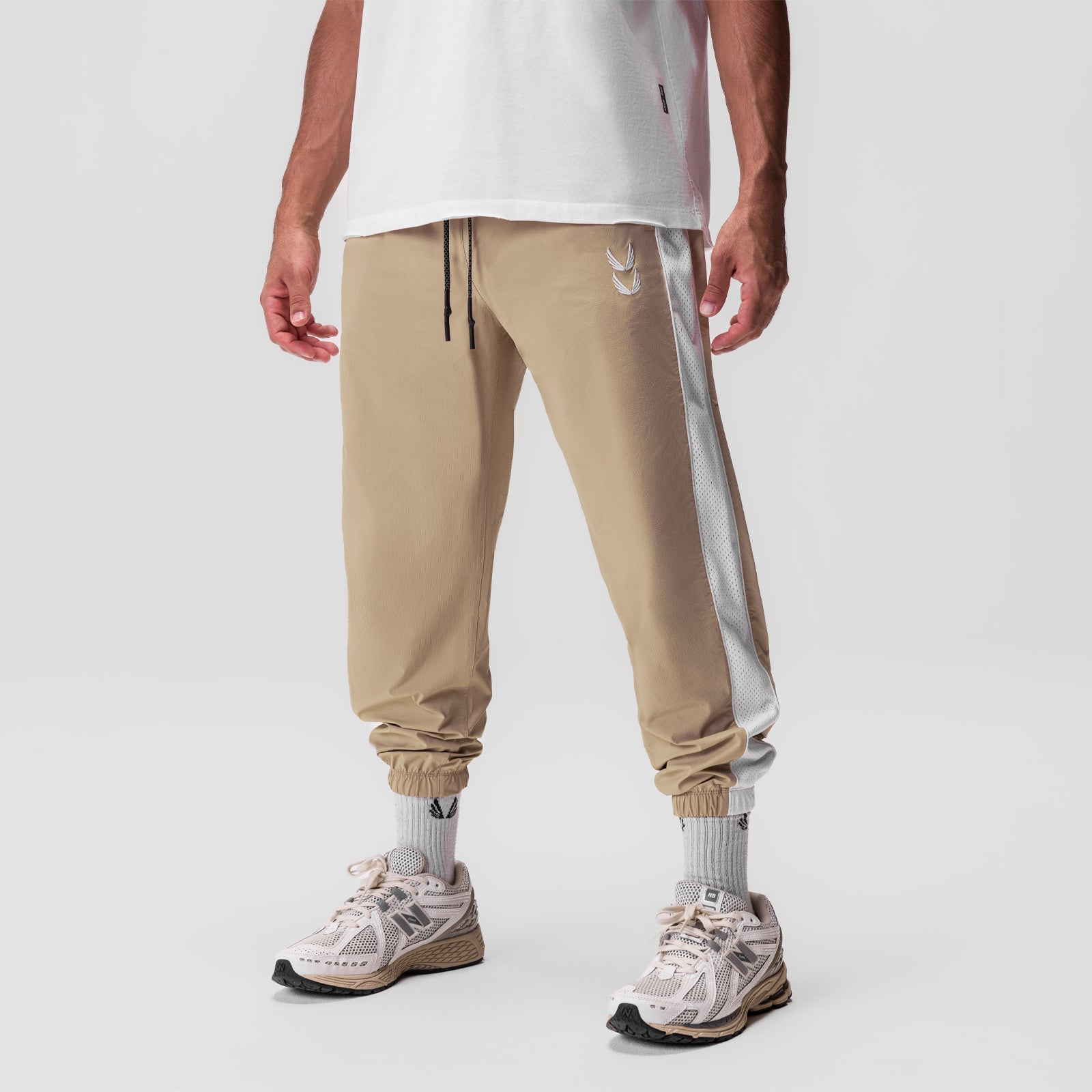 Khaki ripstop oversized track pant with grey side stripe, worn with white socks and pink sneakers