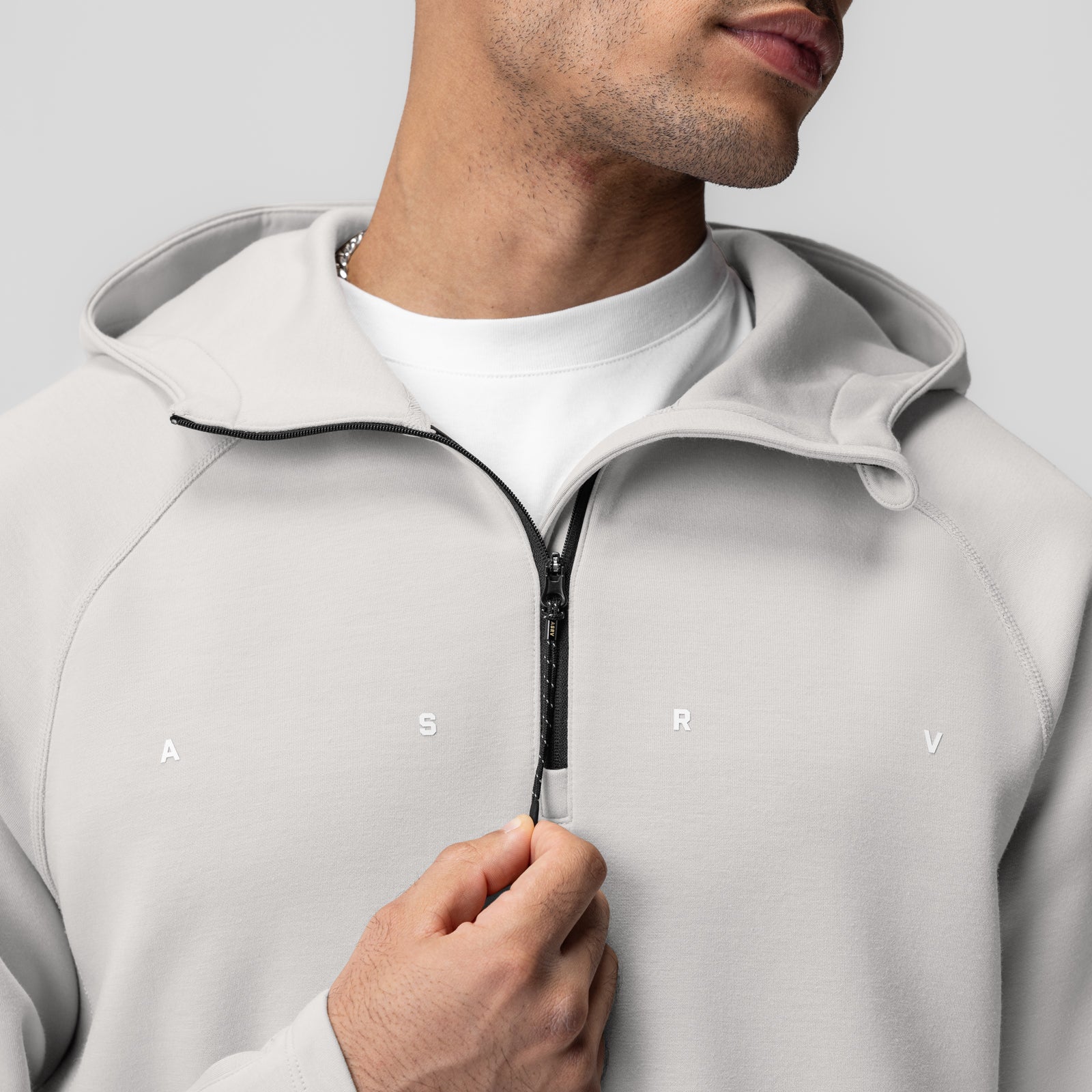 Dri-Core™ Zip Hoodie in light grey, modeled by man holding zipper pull