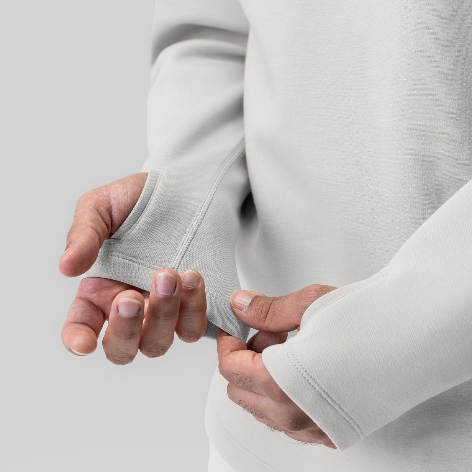Dri-Core Zip Hoodie in light grey, model holding fabric detail close-up