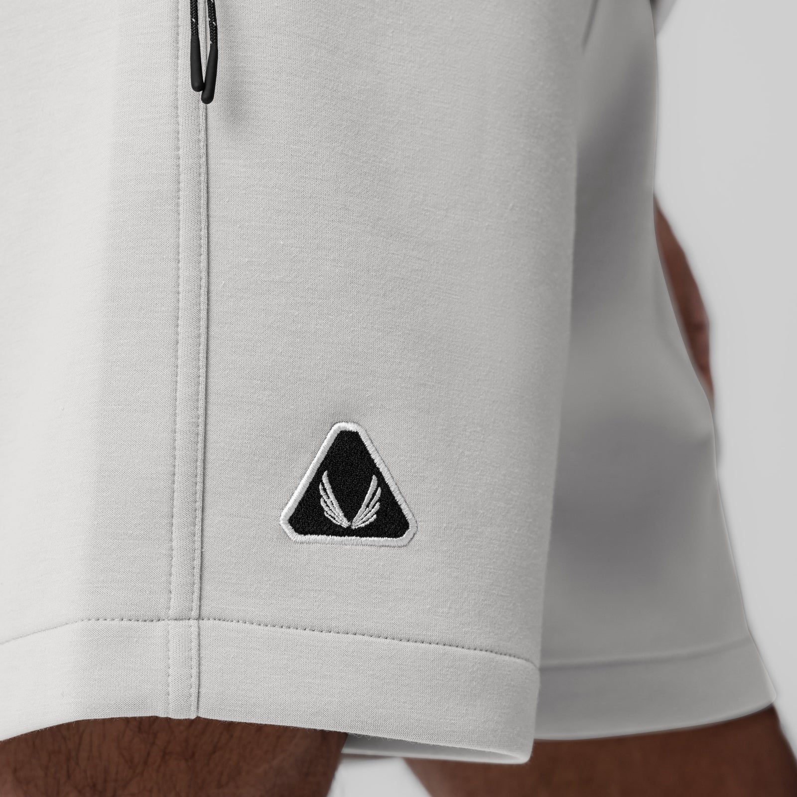 Dri-Core Training Short in light grey, worn on model, showing side detail with embroidered logo