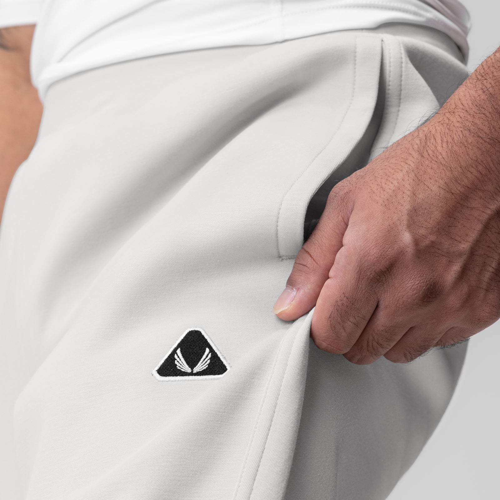 Dri-Core Training Jogger in light grey worn by model, side pocket detail with logo