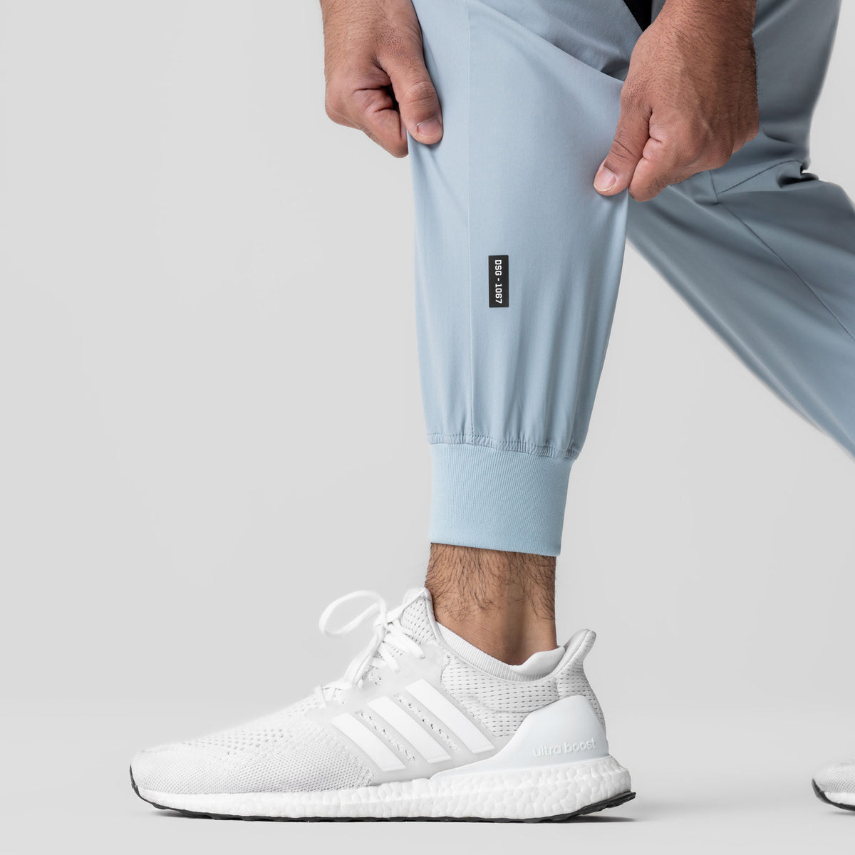 Tetra-Lite Cuffed Training Jogger in light sky worn with white sneakers, front view
