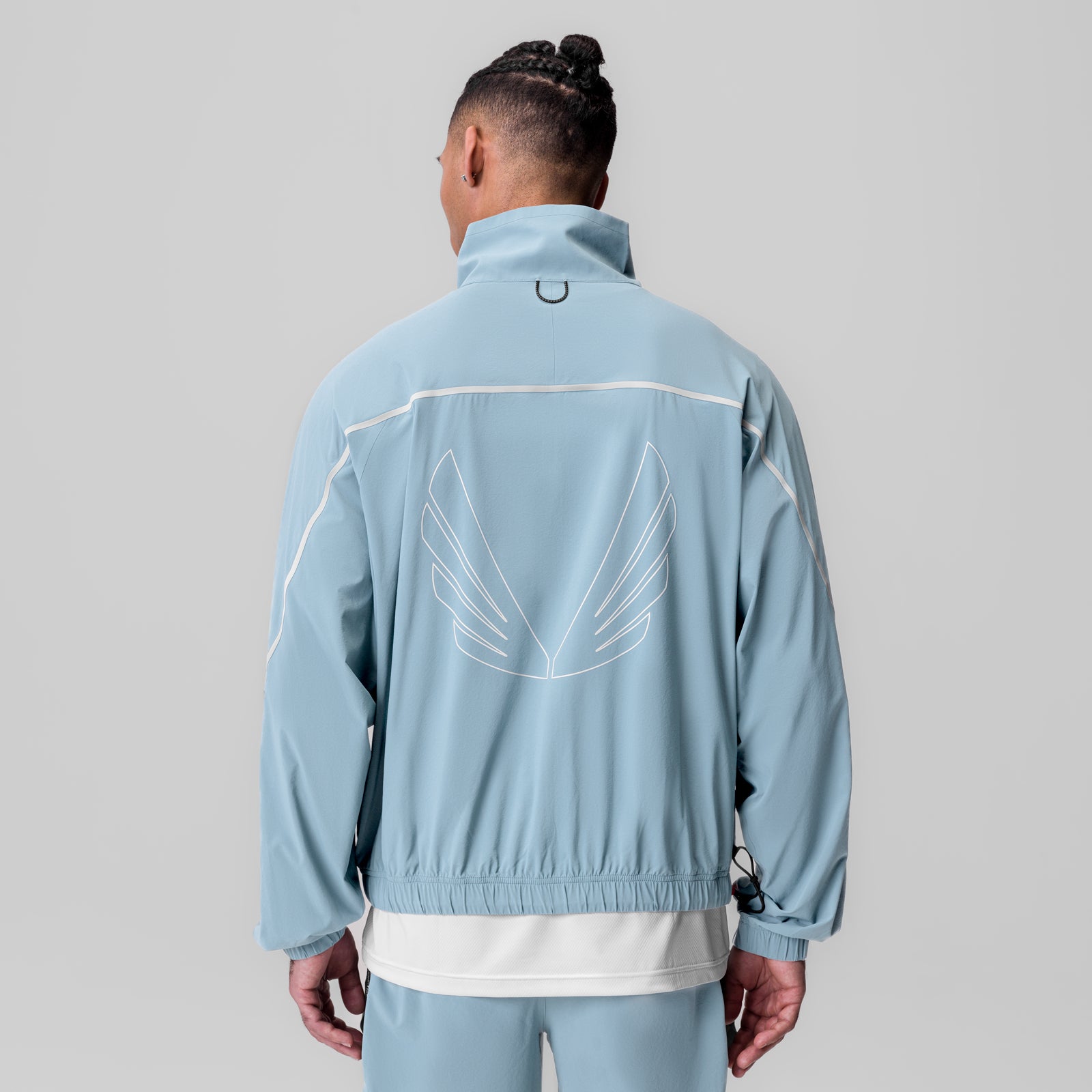 Aerotex Track Jacket in light sky blue worn by model, back view showing wings graphic