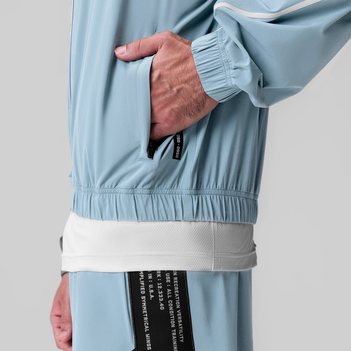 Aerotex™ Track Jacket in Light Sky, model wearing jacket with hand in pocket, detail view