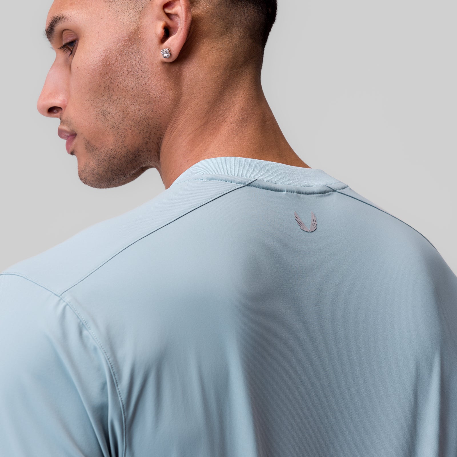Tetra-Lite® Ice Zip Tee in light sky, worn by model shown from side profile