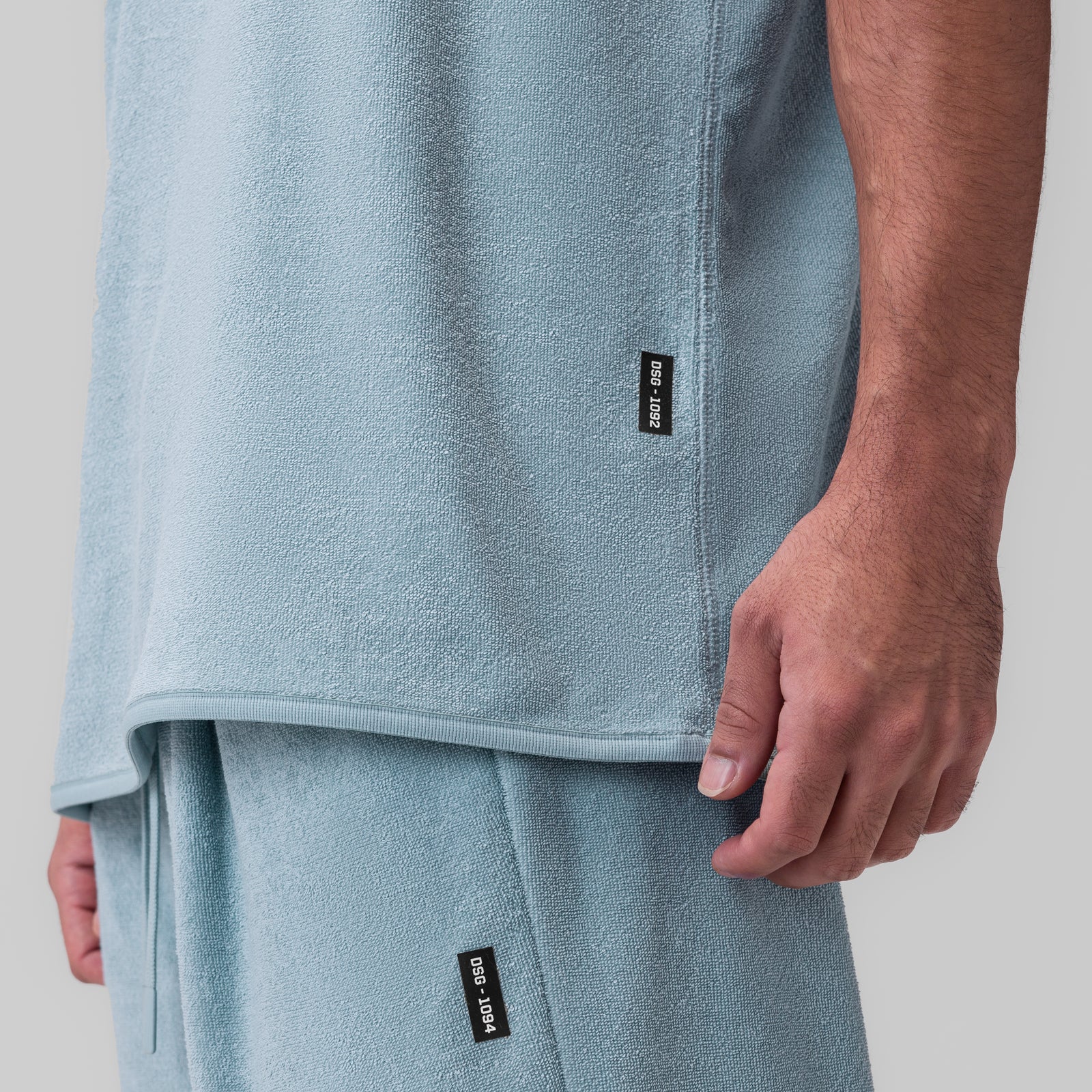 Towel Terry Cutoff in Light Sky worn by model, side detail view showing fabric texture and brand label