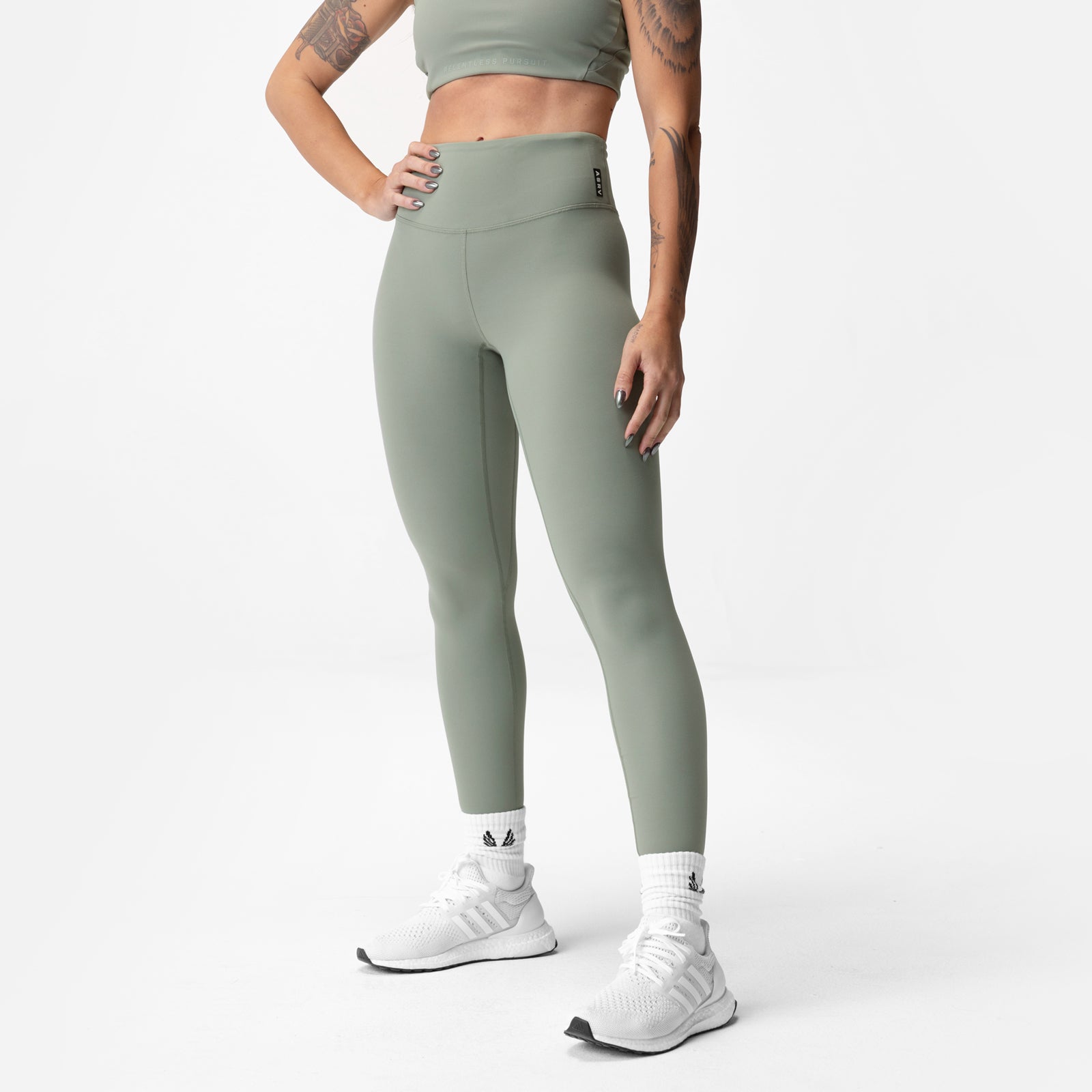 Sage green 7/8 legging worn with white sneakers, front-side view