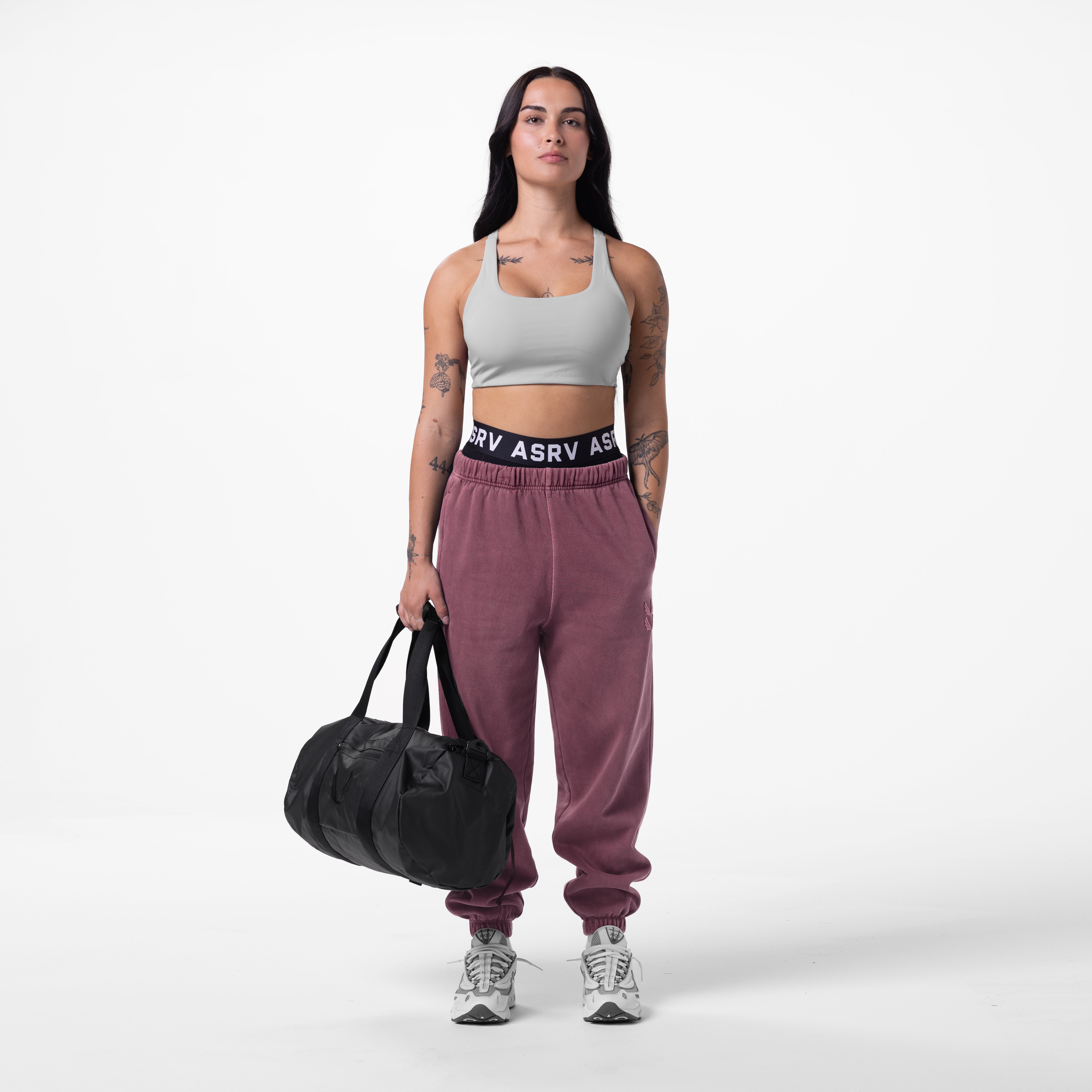 Tech Essential™ Sweats in faded crimson, worn by model holding black duffle bag
