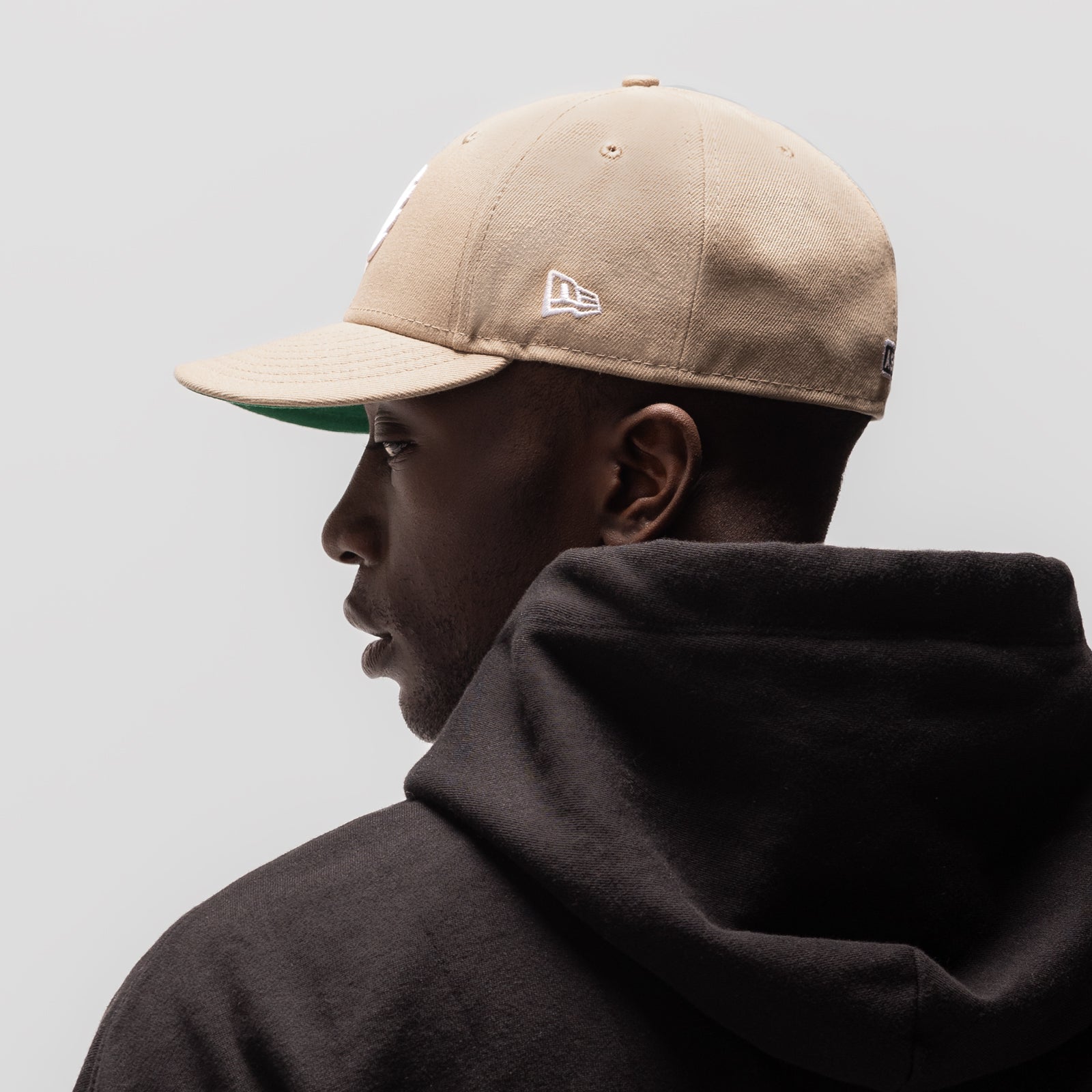 New Era 59Fifty Low Profile Hat in beige with white logo, worn by model in profile view
