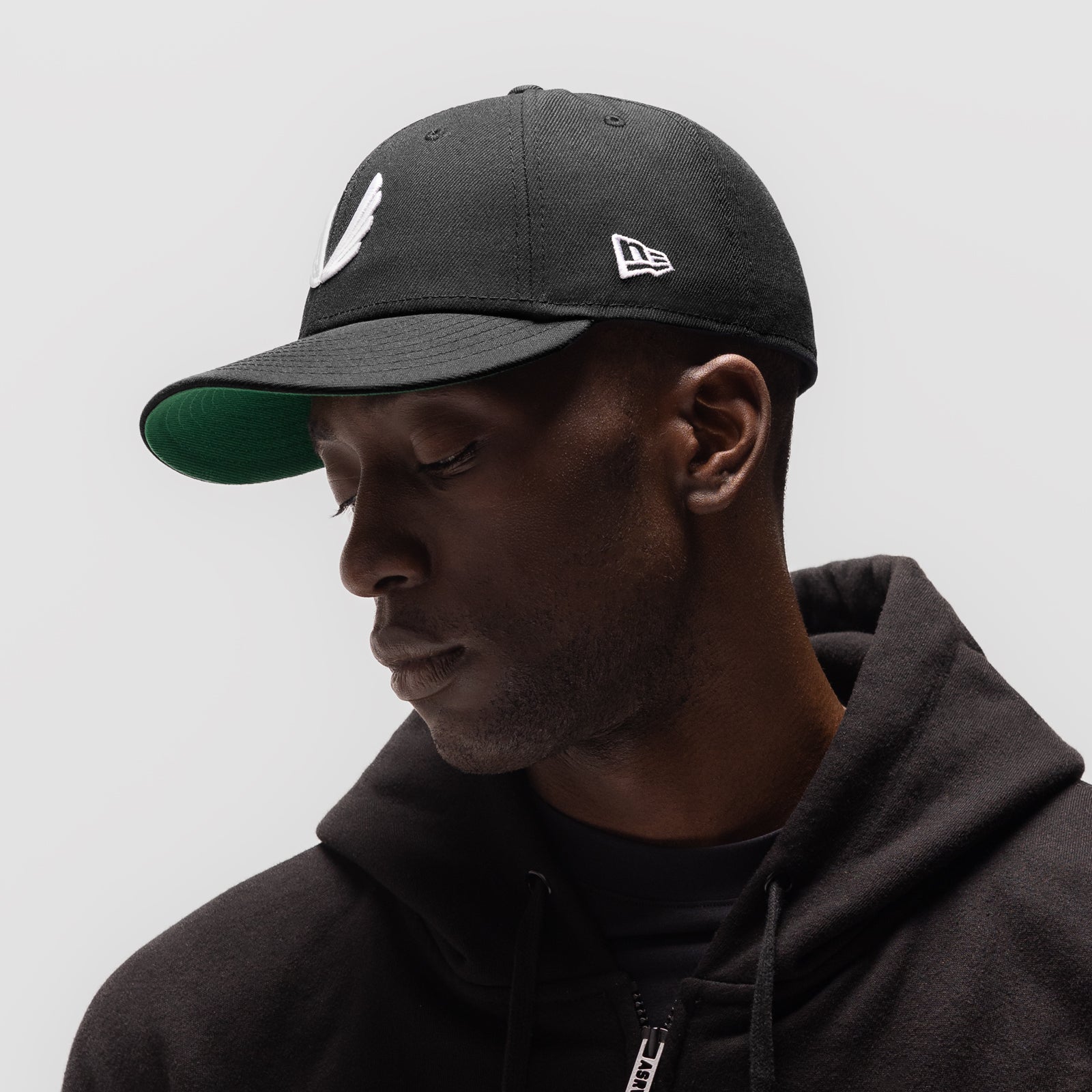 New Era 59Fifty Low Profile Hat in black with white wings logo, worn by model in side profile