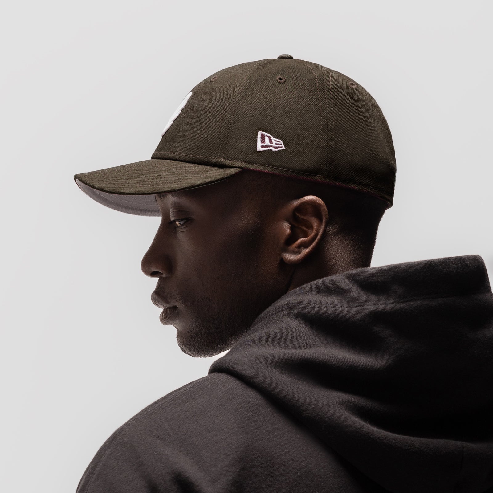 New Era 59Fifty Low Profile Hat in dark earth, worn by model in profile view