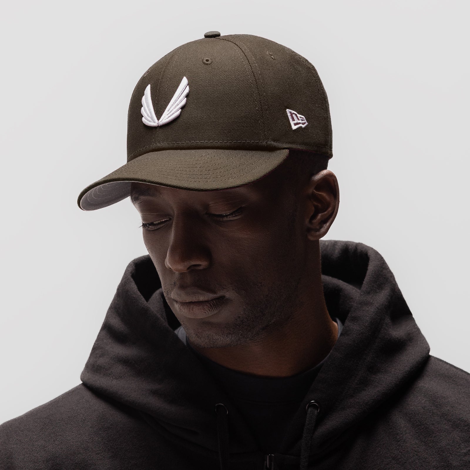 New Era 59Fifty Low Profile Hat in dark earth with white wings logo, worn by model