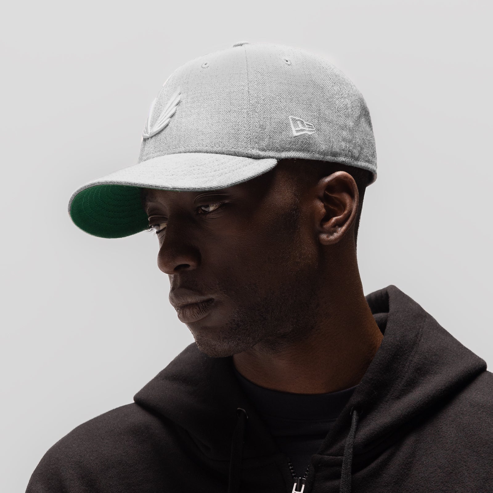 New Era 59Fifty Low Profile Hat in heather grey with white visor, worn by model in profile