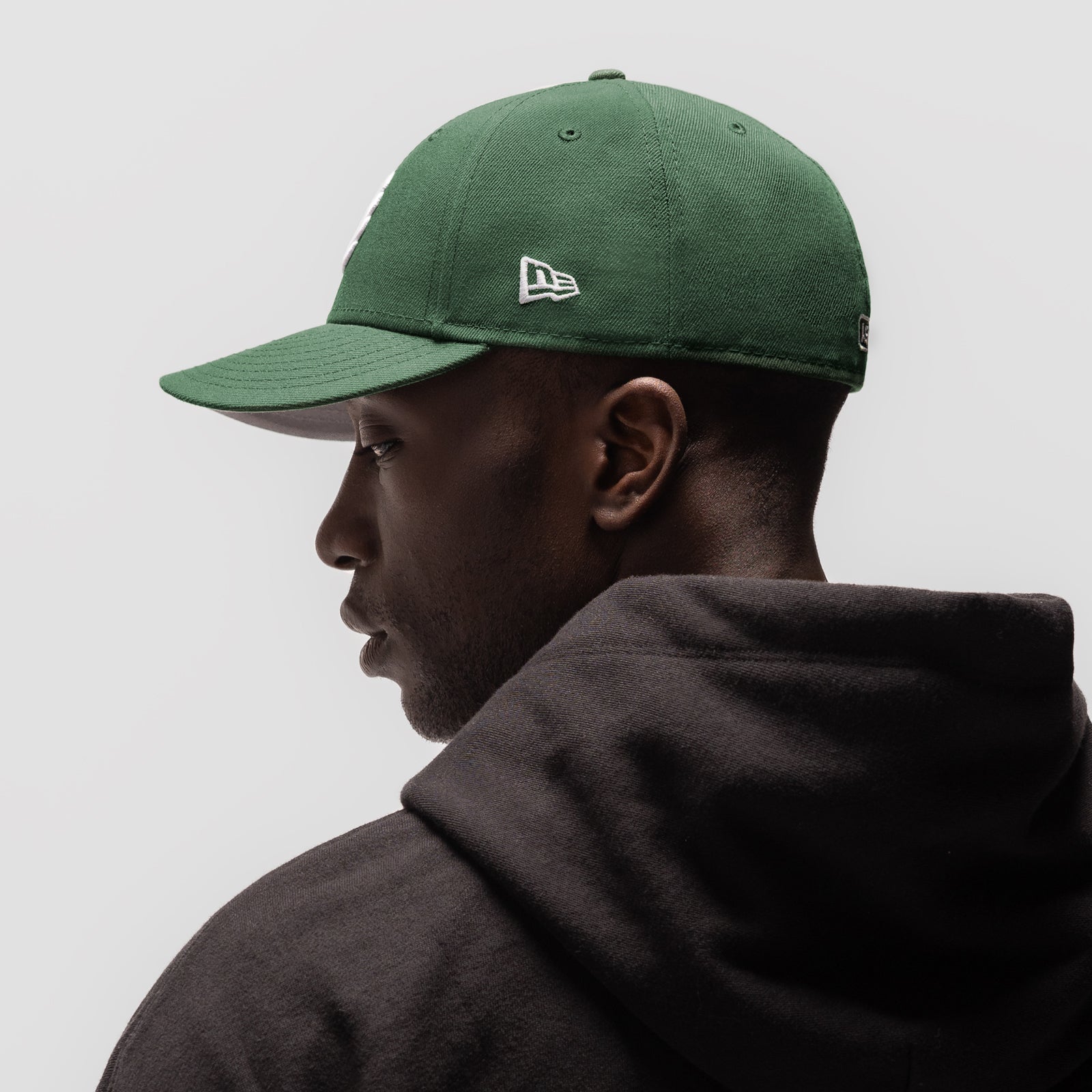New Era 59Fifty Low Profile Hat in forest green, worn by model in profile view